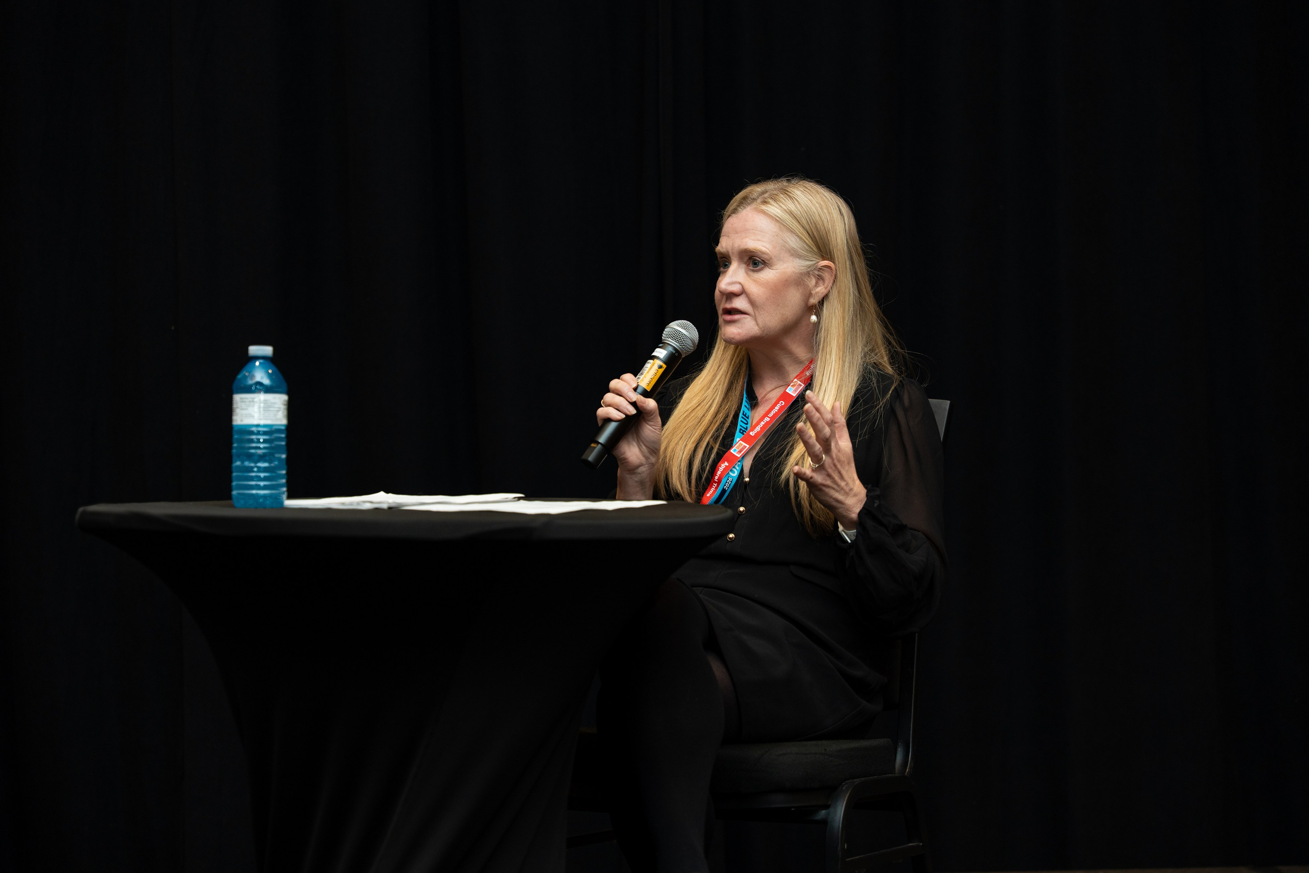 Speaker with microphone addressing audience, Blueline Expo 2026