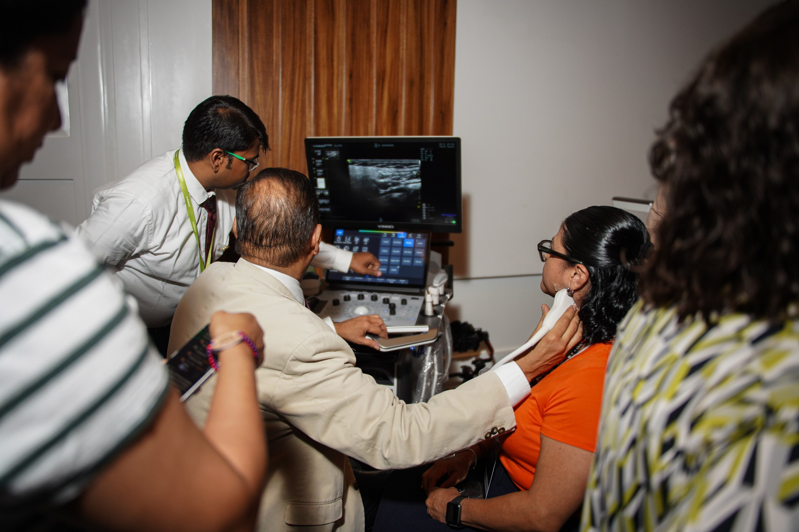 Specialist explaining features of modern diagnostic machine to audience.