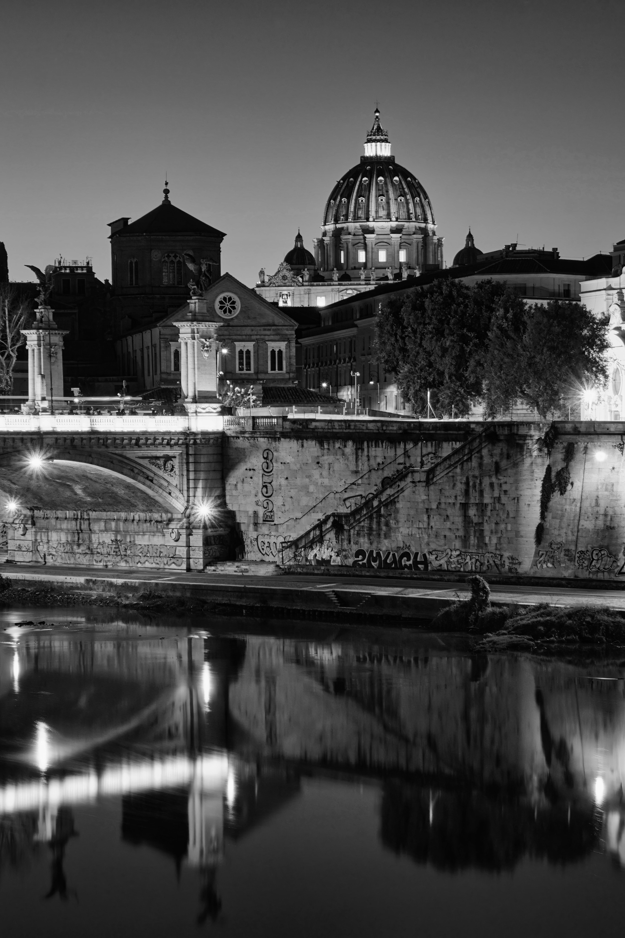 Rome Italy – Ponte Vittorio Emanuele II over the Tiber River at sunset, early 20th-century monumental bridge architecture photographed in black and white fine art photography. Rome, Italy – fine art photography by Eduardo Bartoli.