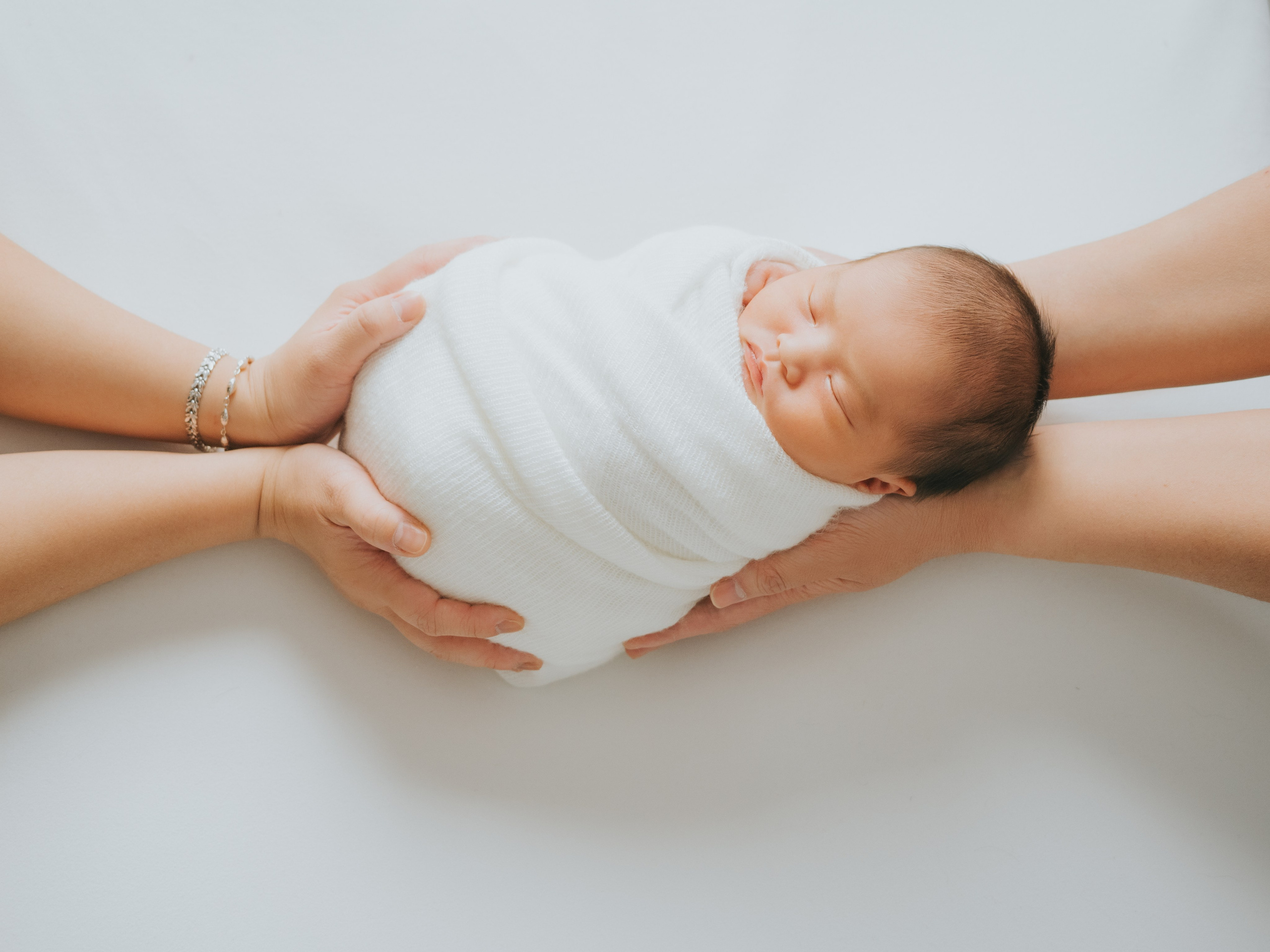 Les mains des parents tenant le nouveau-né.