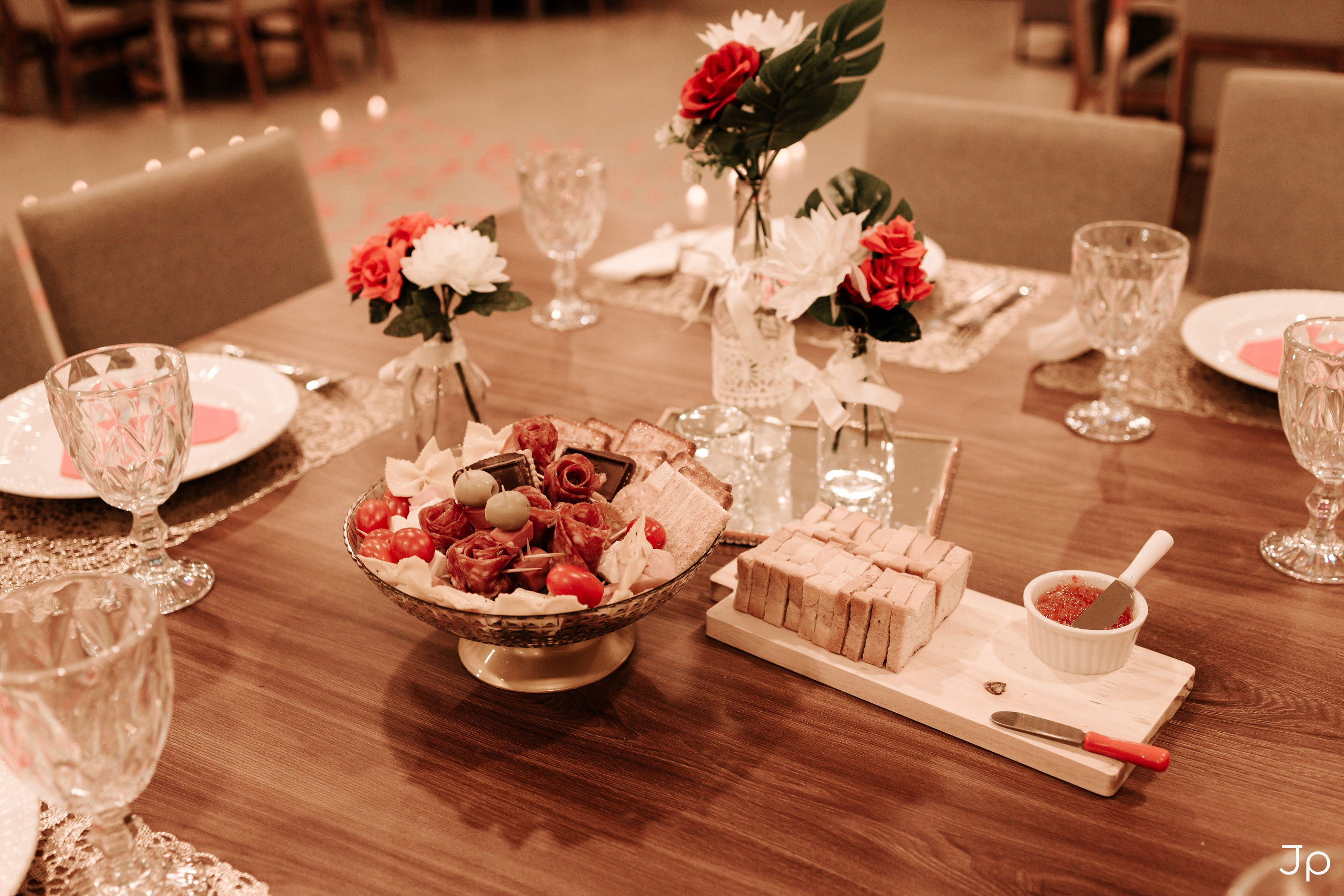 Centro de mesa decorado com flores e taças.