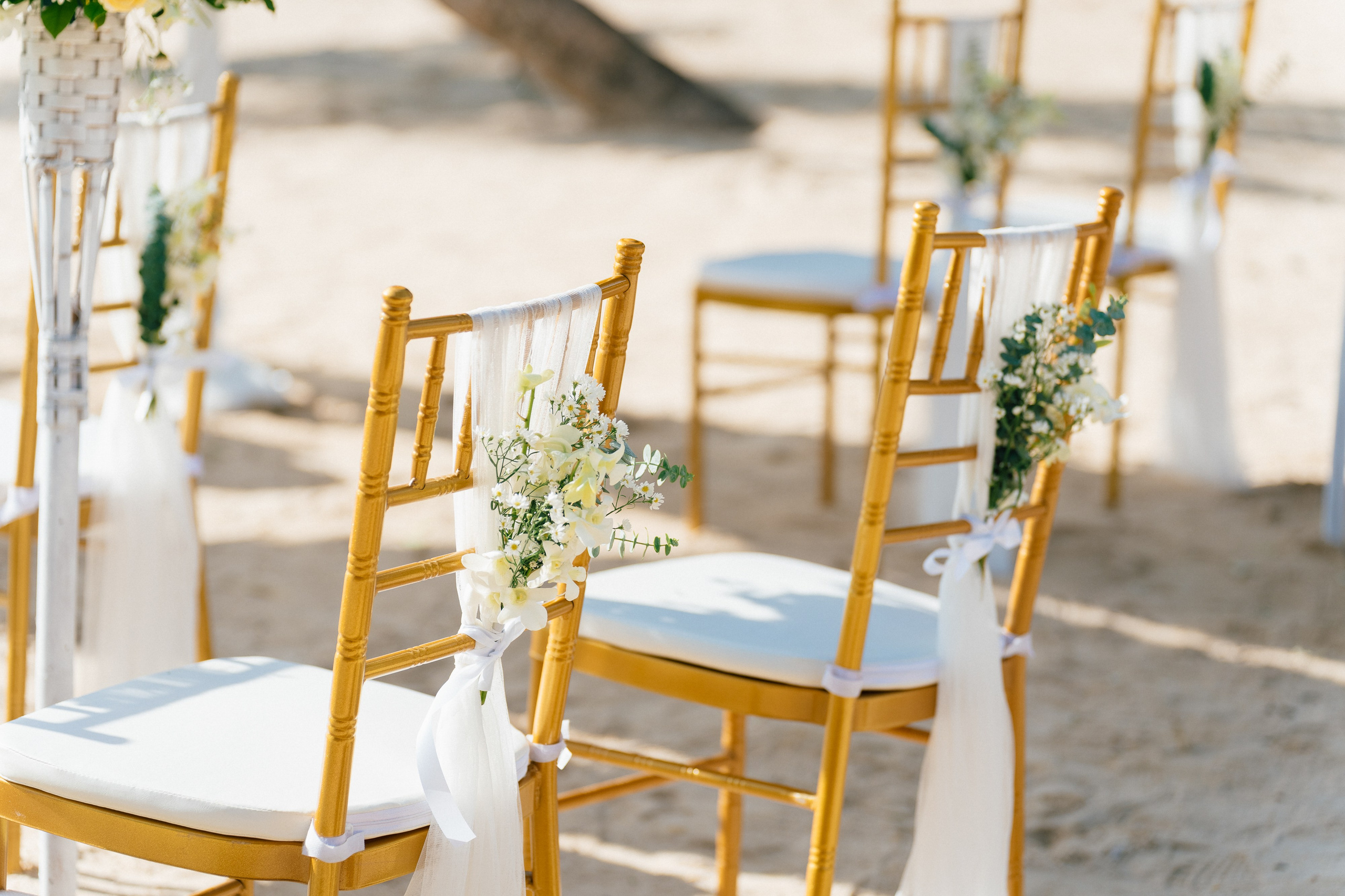 Newlywed couple celebrating a Buddhist wedding ceremony on a beautiful beach in Koh Samui, Thailand.