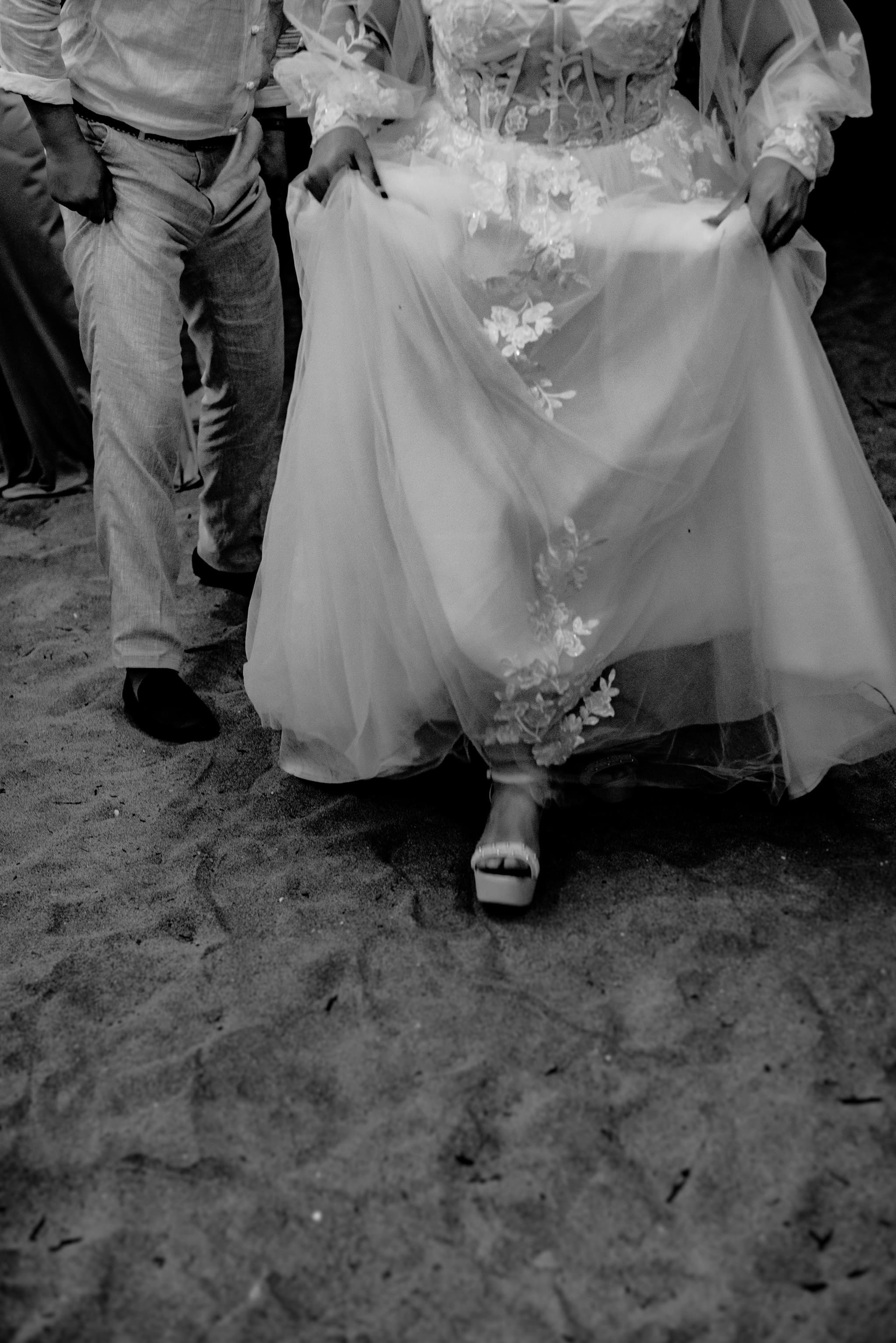 Acercamiento de pareja en fiesta matrimonial nocturna, momento romántico en boda de playa