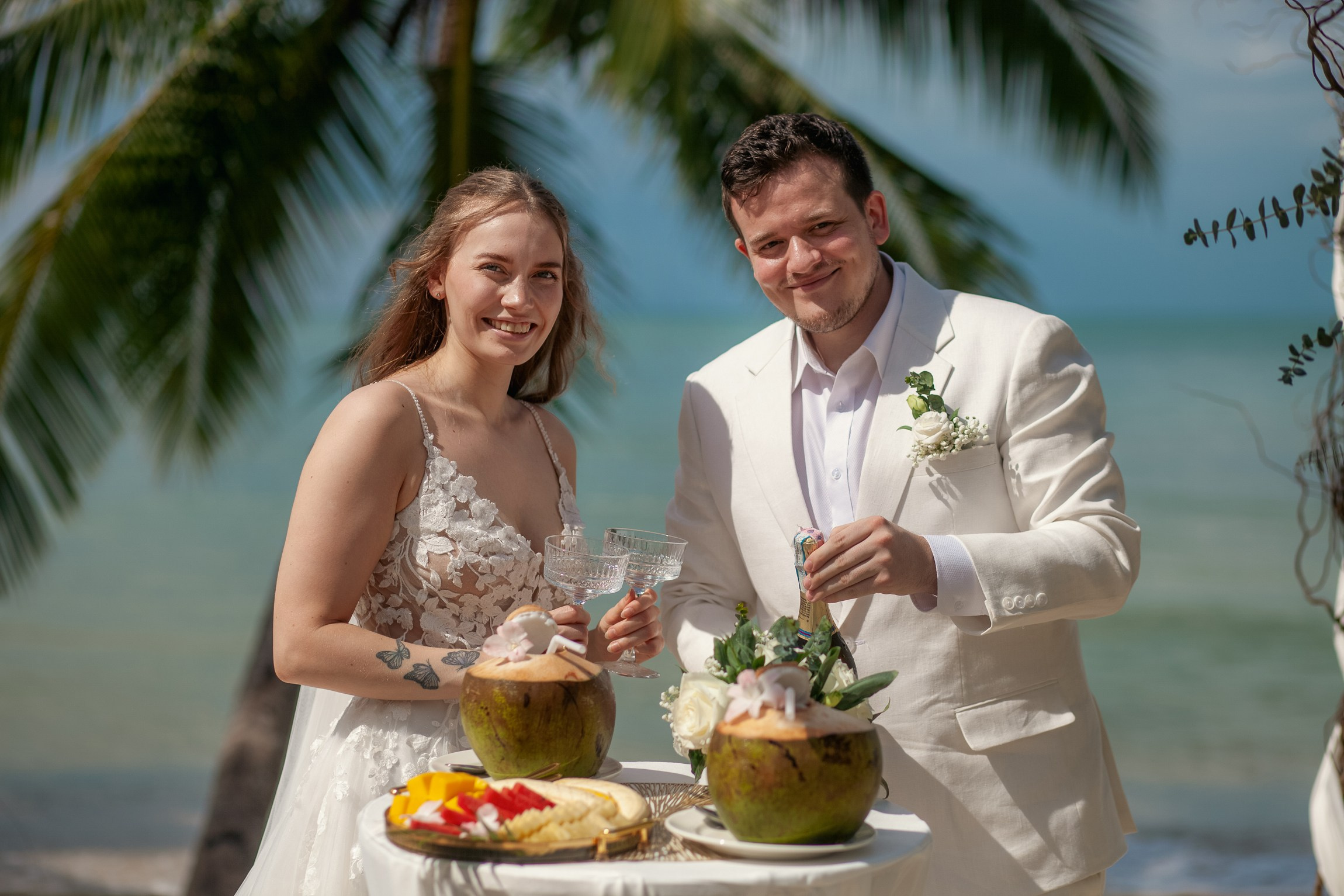 Romantic destination wedding on Koh Samui beach with tropical flowers, ocean views and happy newlyweds