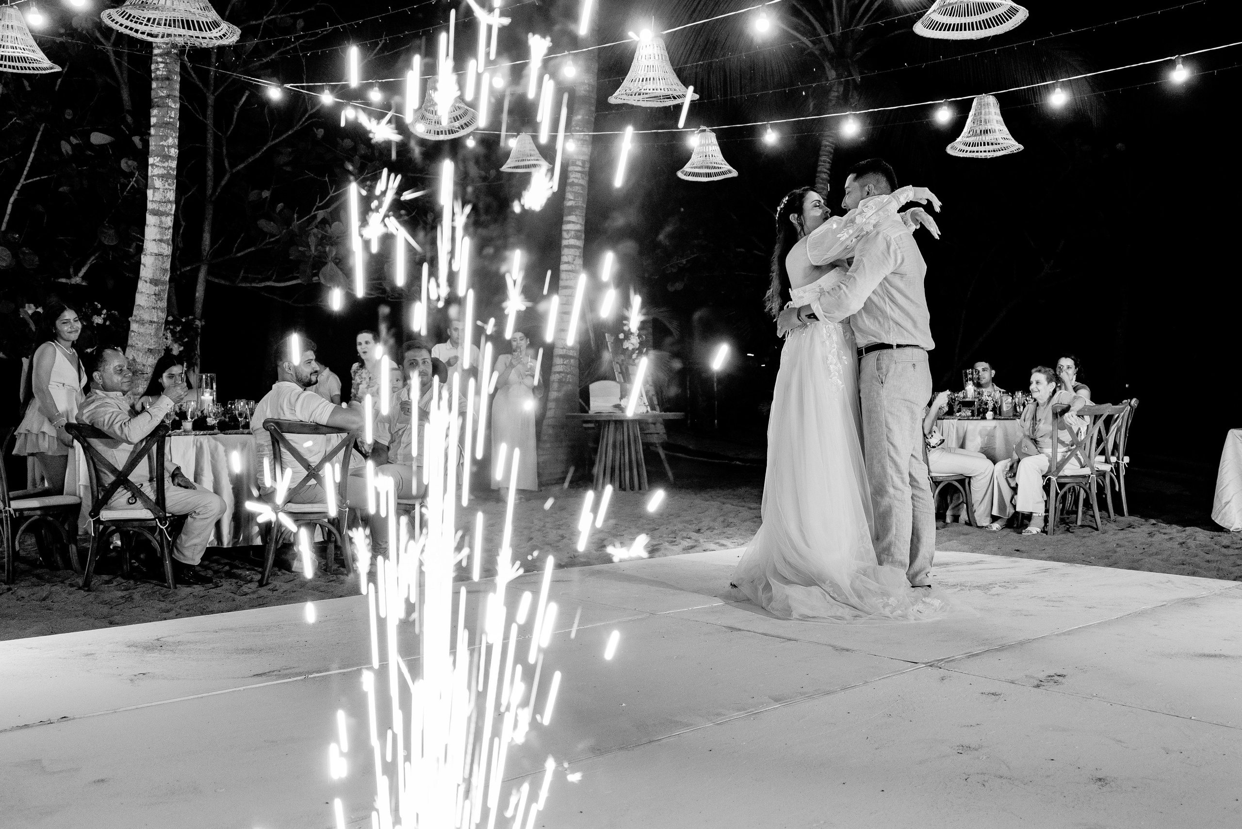 Danza y movimiento en fiesta de boda nocturna, pareja bailando con iluminación ambiente tropical