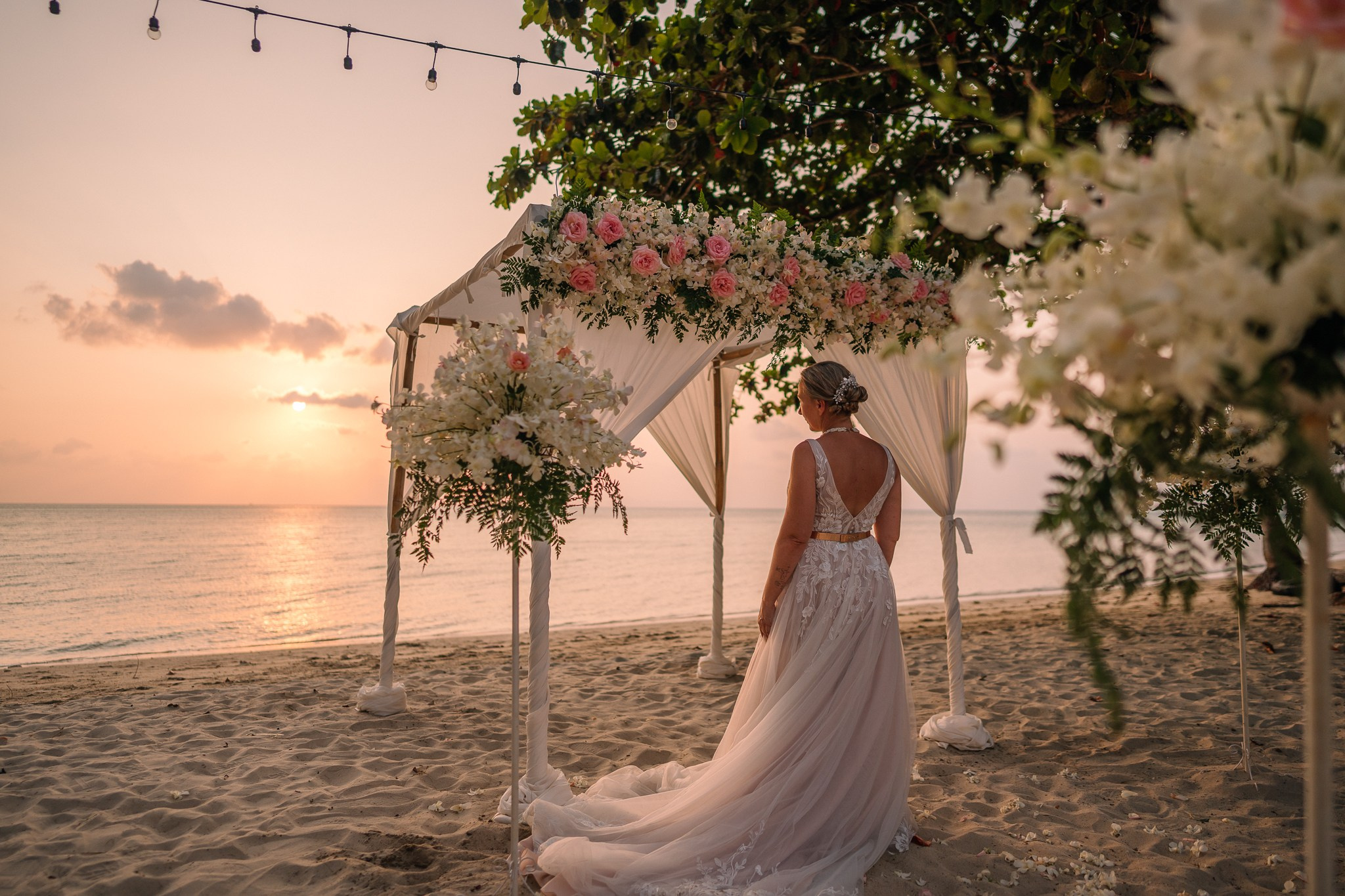 Bride and groom celebrating a beautiful beach wedding in Koh Samui, Thailand, surrounded by friends and family with tropical ocean views