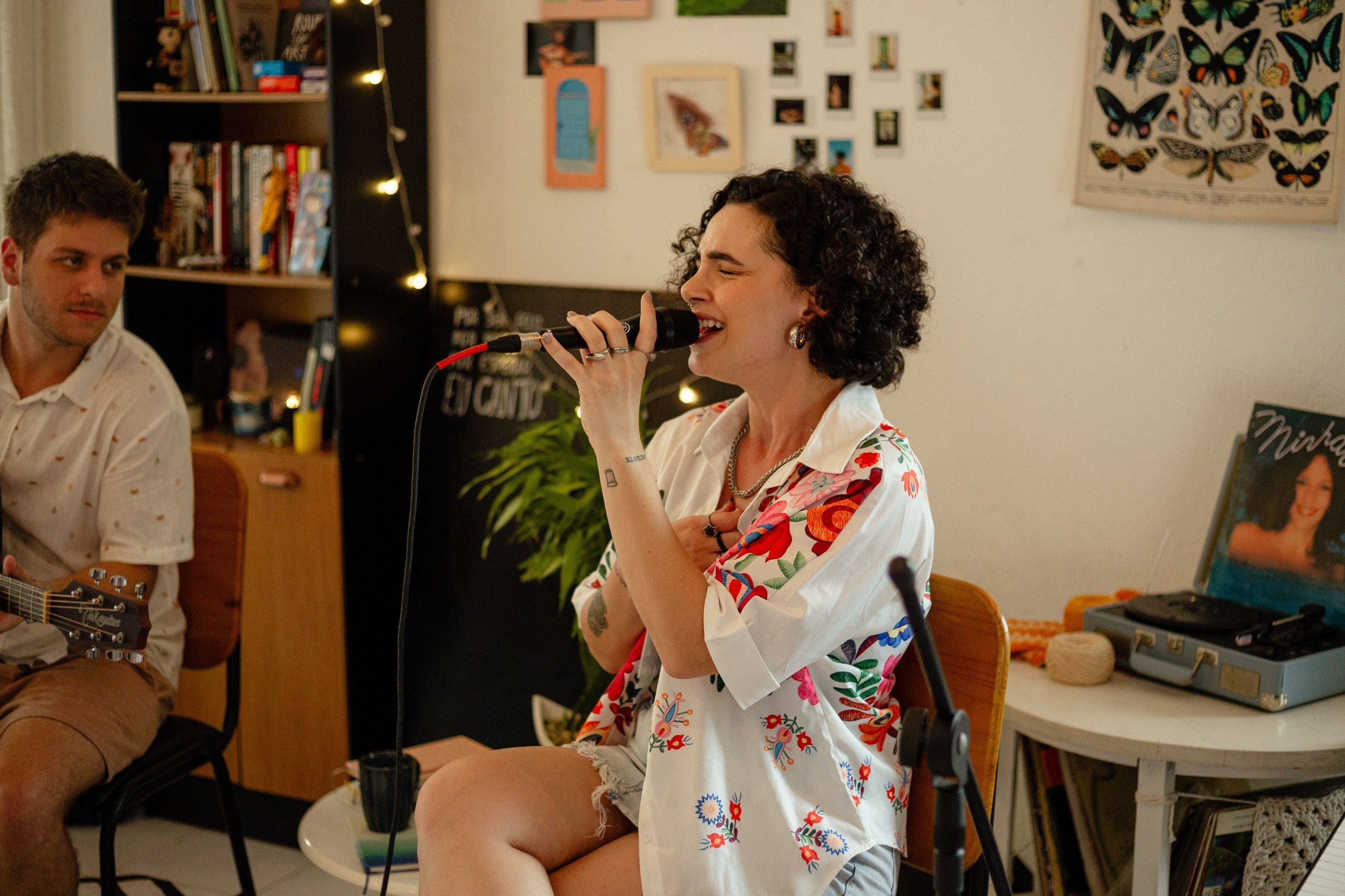 Cantora e músico se apresentando ao vivo durante cobertura fotográfica de show em Itajaí.