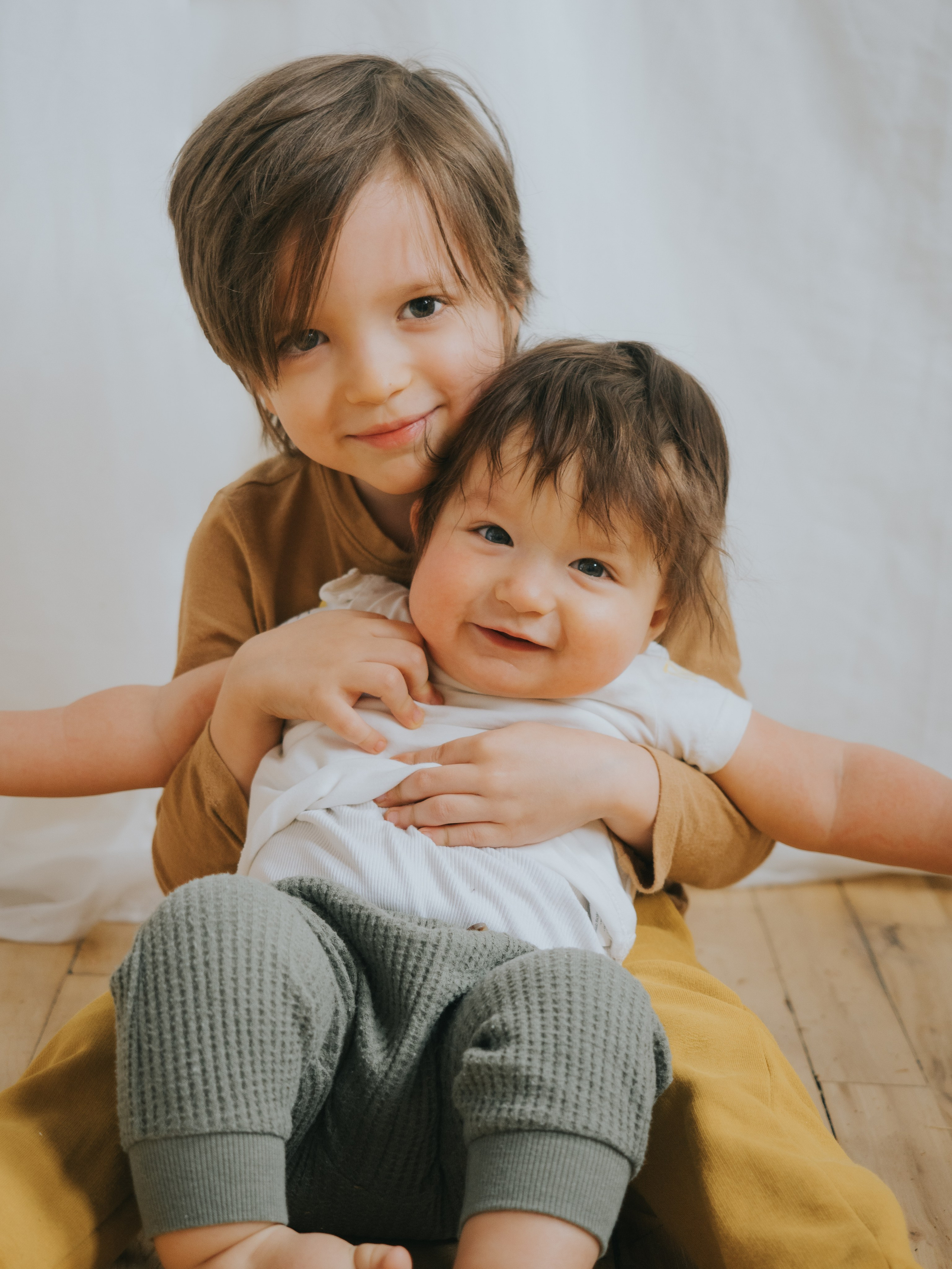 Deux jeunes frères se serrant dans les bras et regardant l'appareil photo.