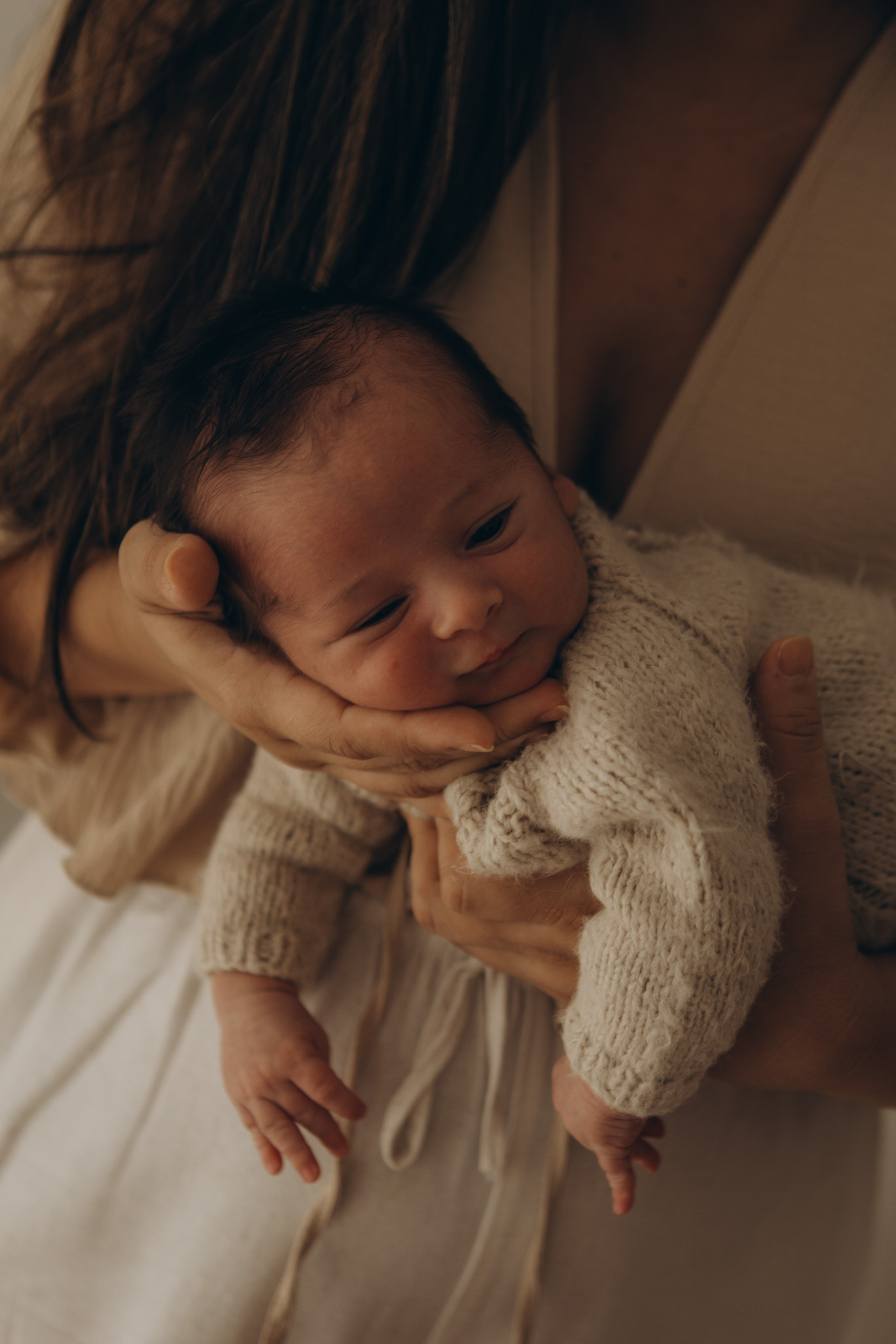 mãe carrega recém-nascido em ensaio newborn afetivo em Sorocaba