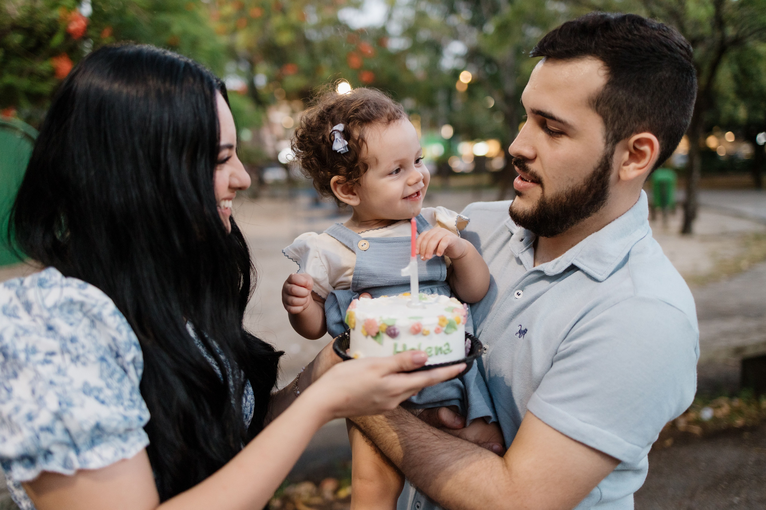 Família cantando parabéns de 1 ano em ensaio no parque