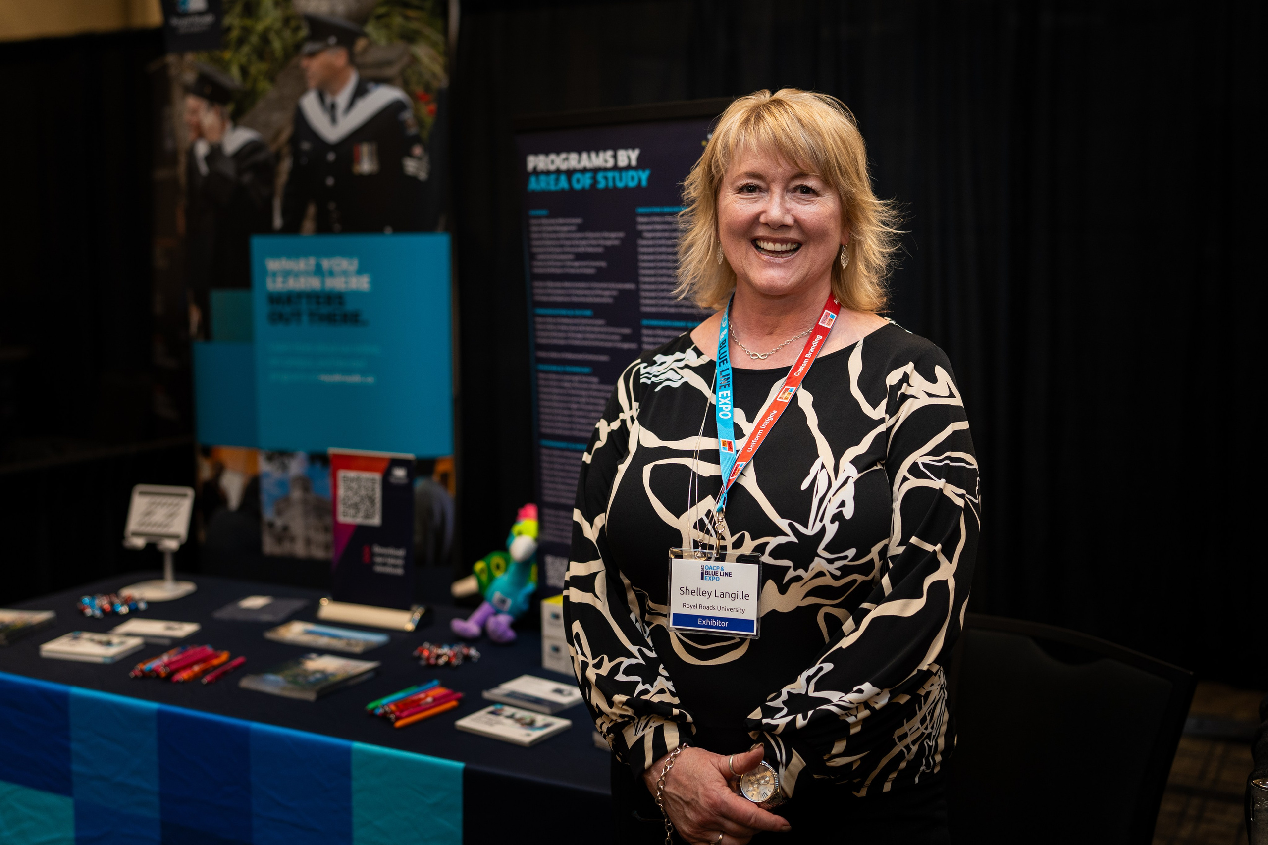 Exhibitor representative smiling at booth, Blueline Expo 2026