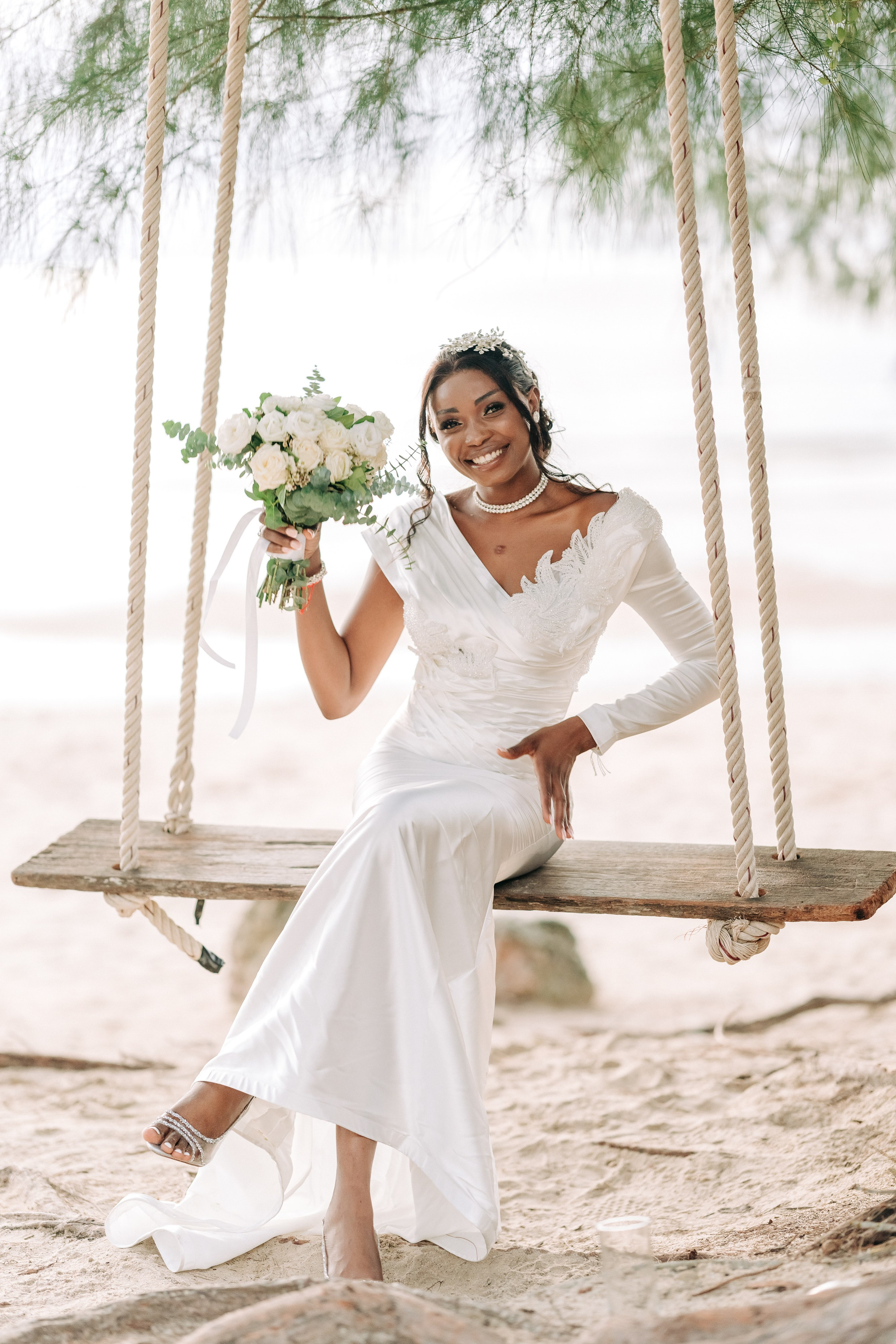 Newlywed couple celebrating a Buddhist wedding ceremony on a beautiful beach in Koh Samui, Thailand.
