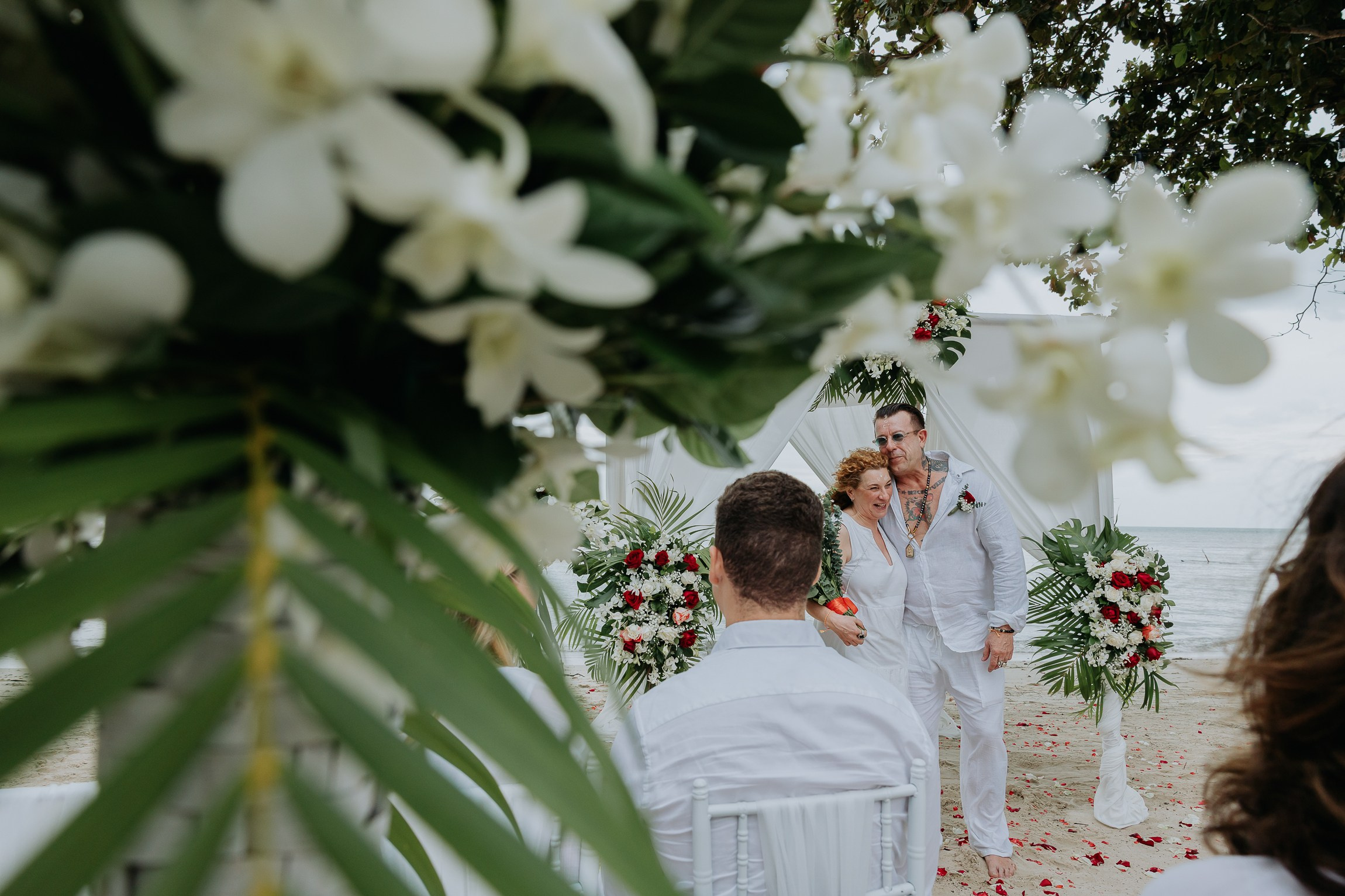 Bride and groom participating in a sacred Buddhist wedding blessing in Thailand