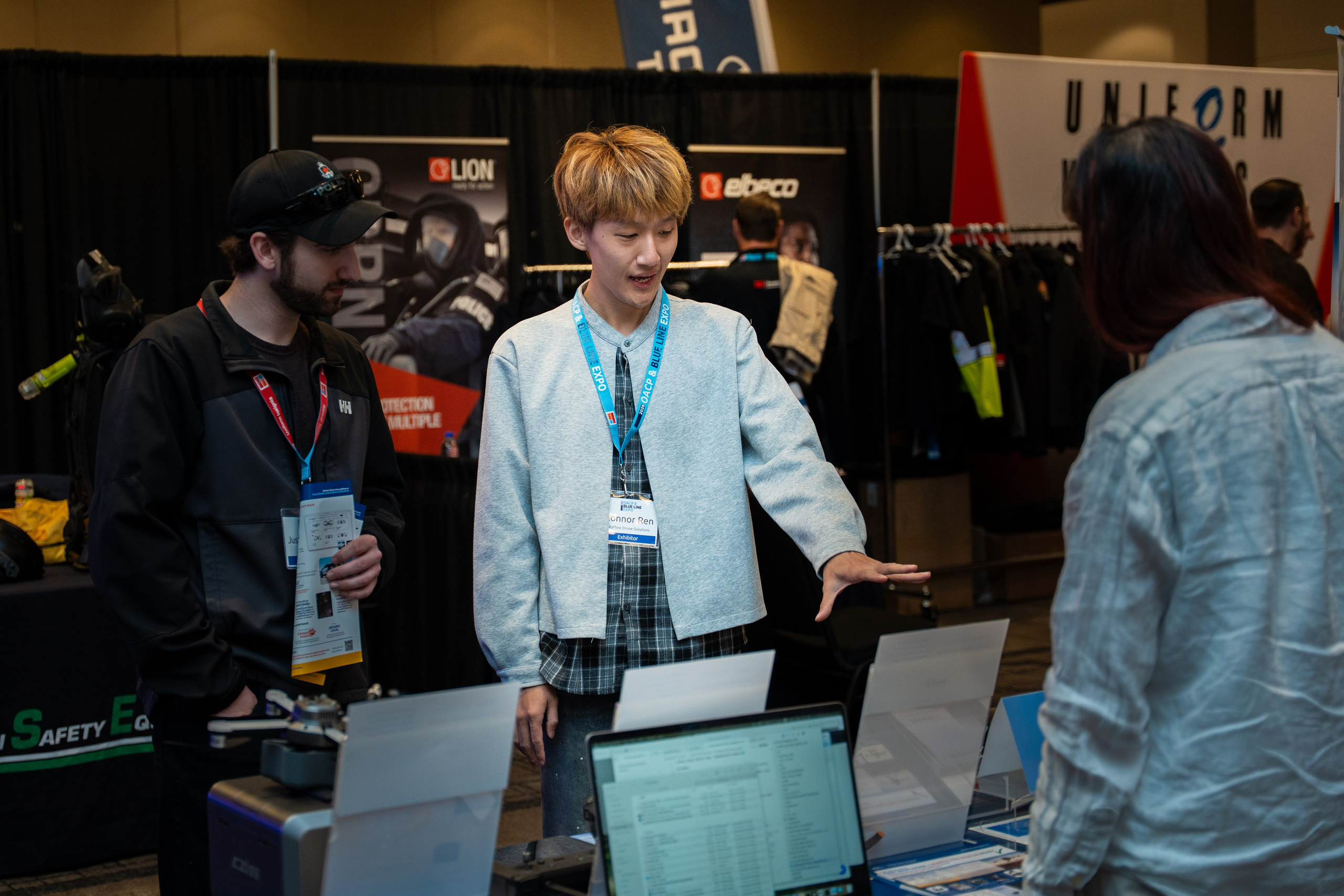 Attendee in teal jacket browsing booth, Blueline Expo