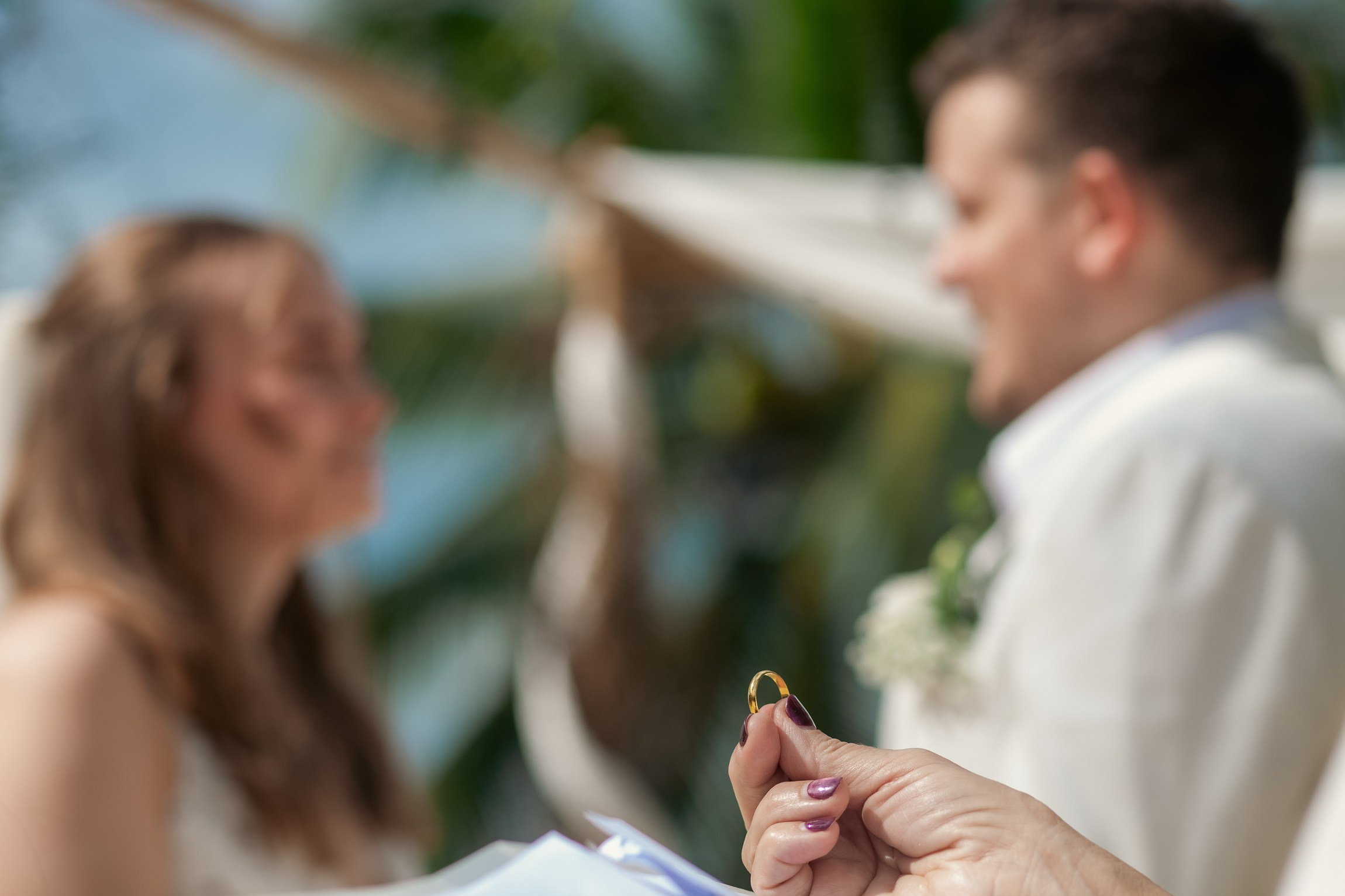 Bride and groom celebrating a beach wedding with their children in Koh Samui, Thailand, surrounded by tropical scenery and ocean views