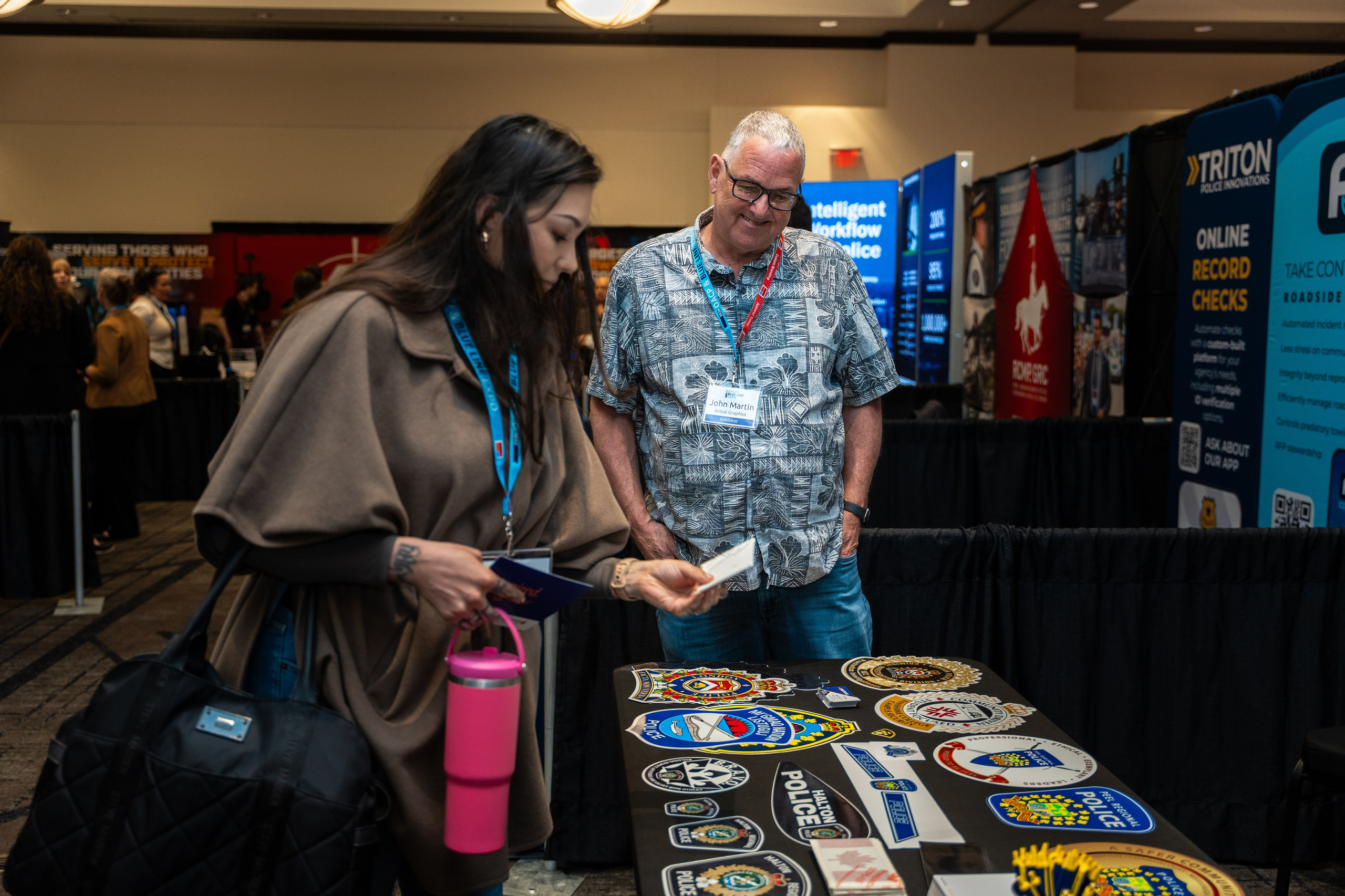 Attendee speaking with exhibitor staff, Blueline Expo 2026