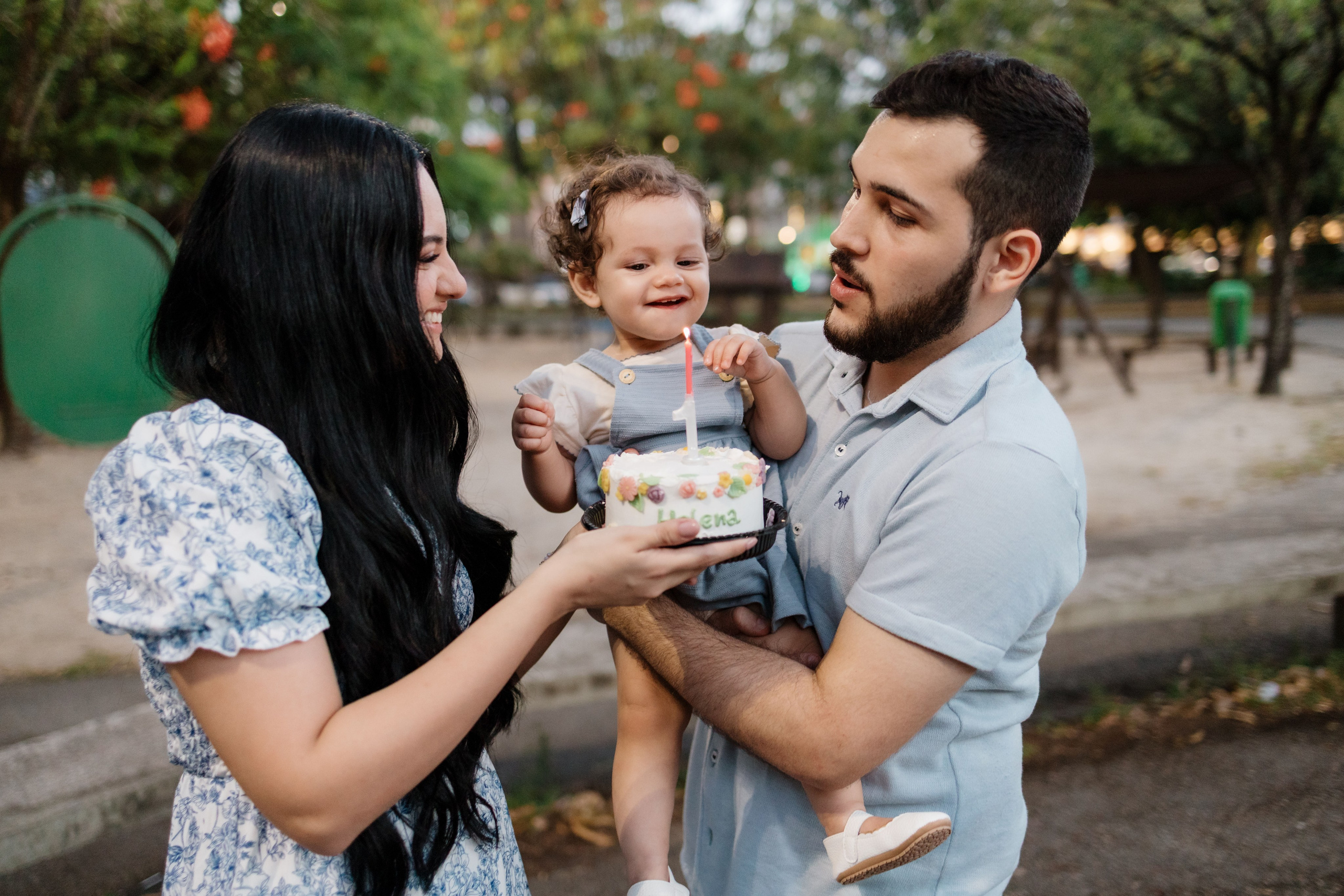 Família cantando parabéns de 1 ano em ensaio no parque