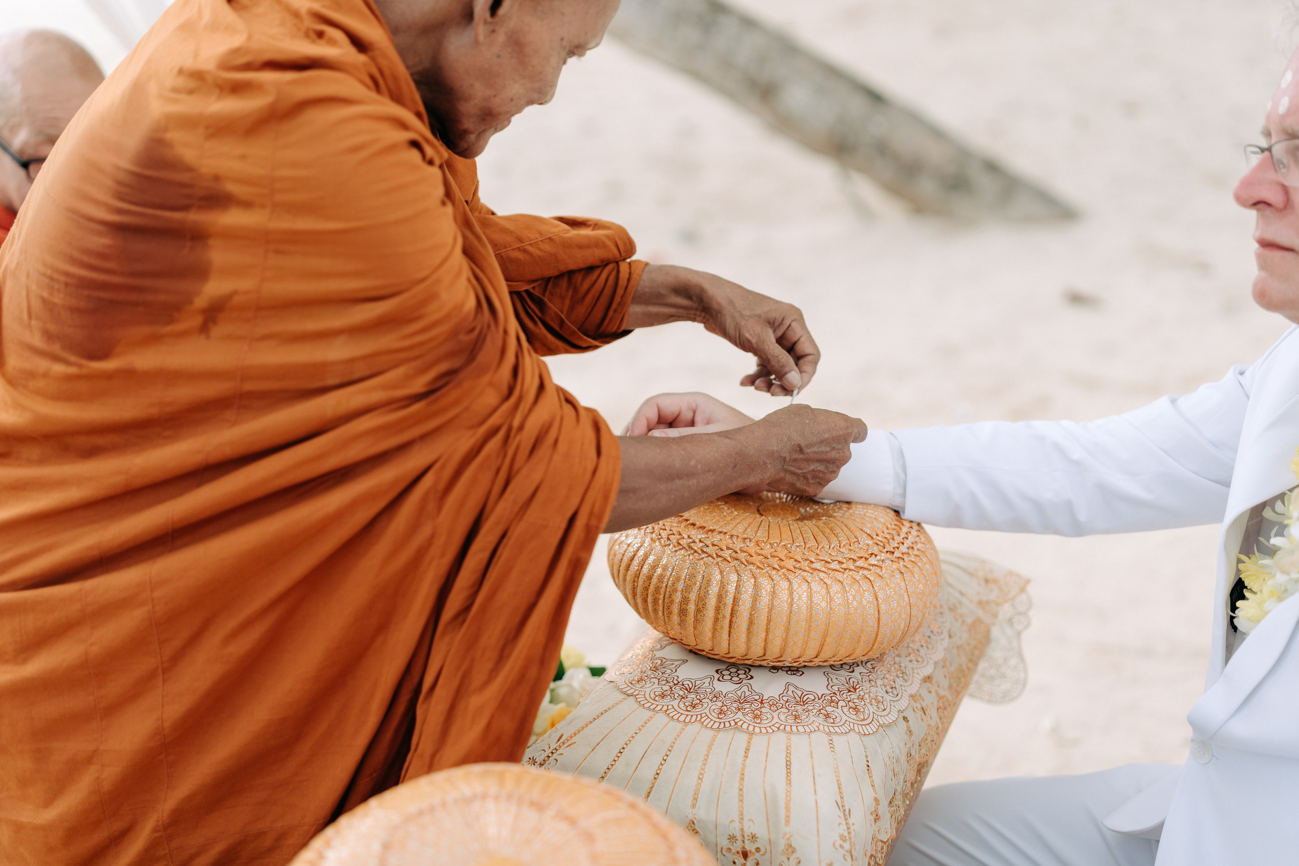 Couple receiving a traditional Buddhist wedding blessing from Thai monks in Koh Samui