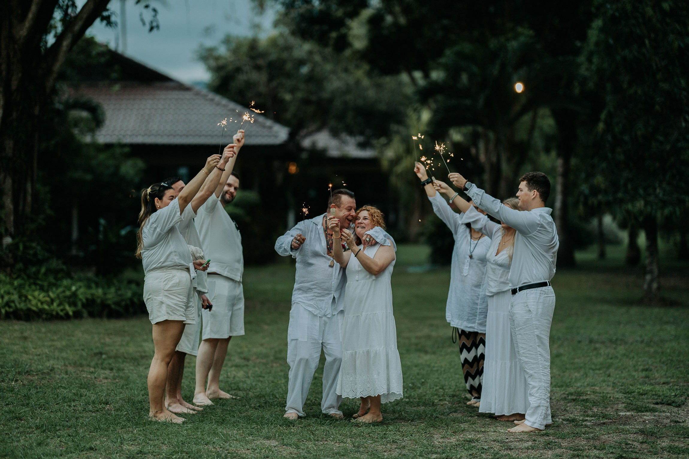 Bride and groom participating in a sacred Buddhist wedding blessing in Thailand