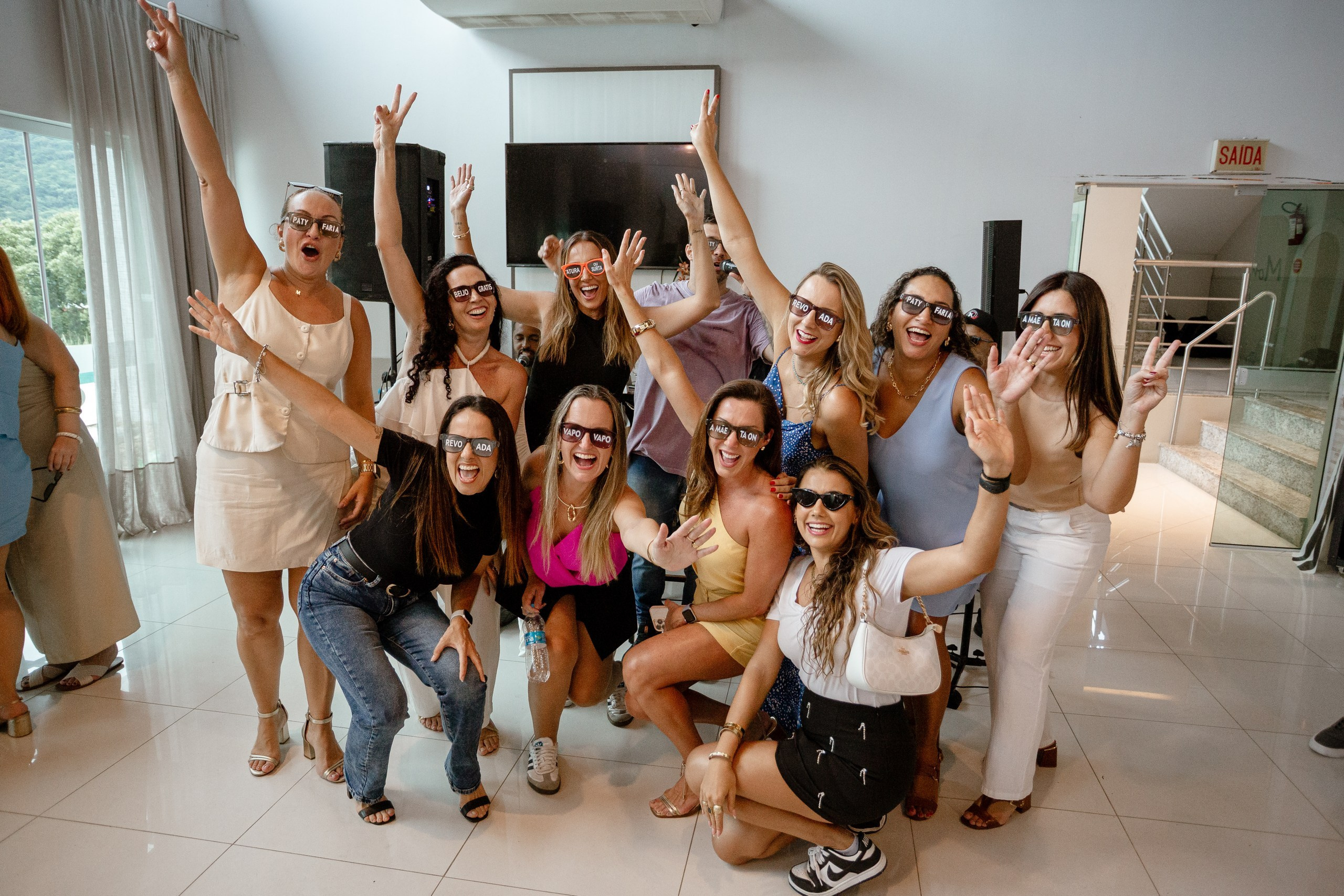 Fotografia de cobertura de festa de aniversário em Itajaí capturando um grupo animado de convidadas posando juntas e celebrando com alegria.