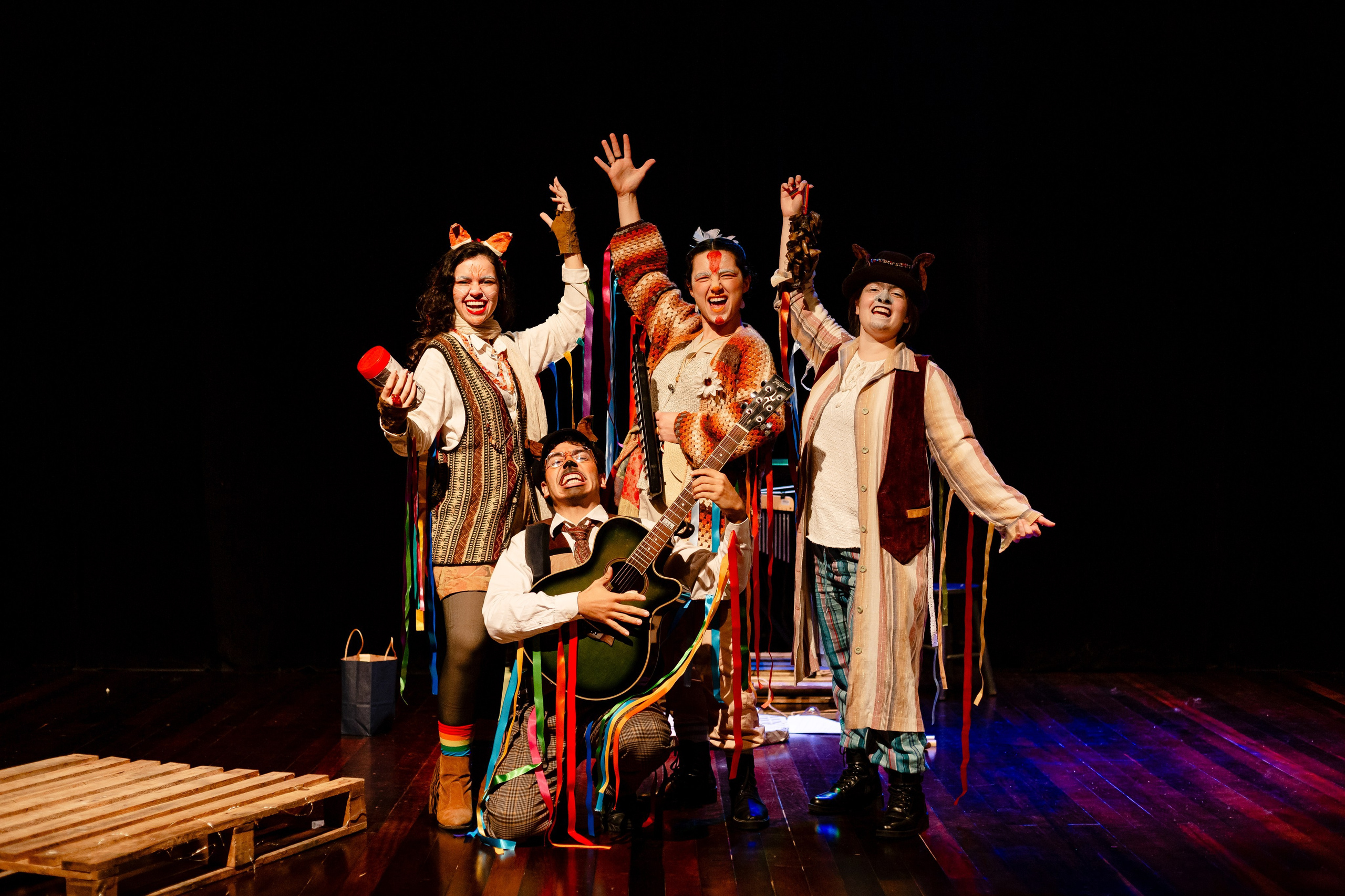 Apresentação teatral com atores juntos e comemorando.