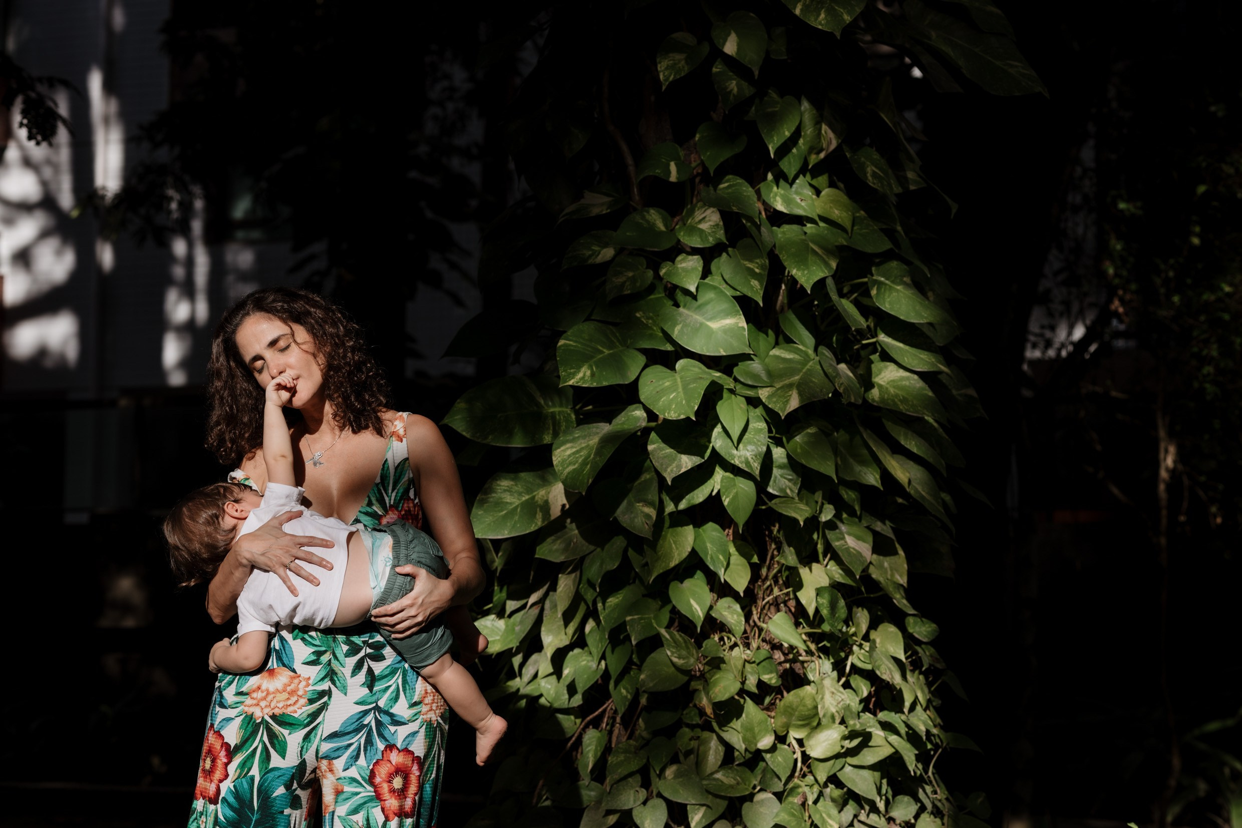 Ensaio de família com mãe amamentando na natureza