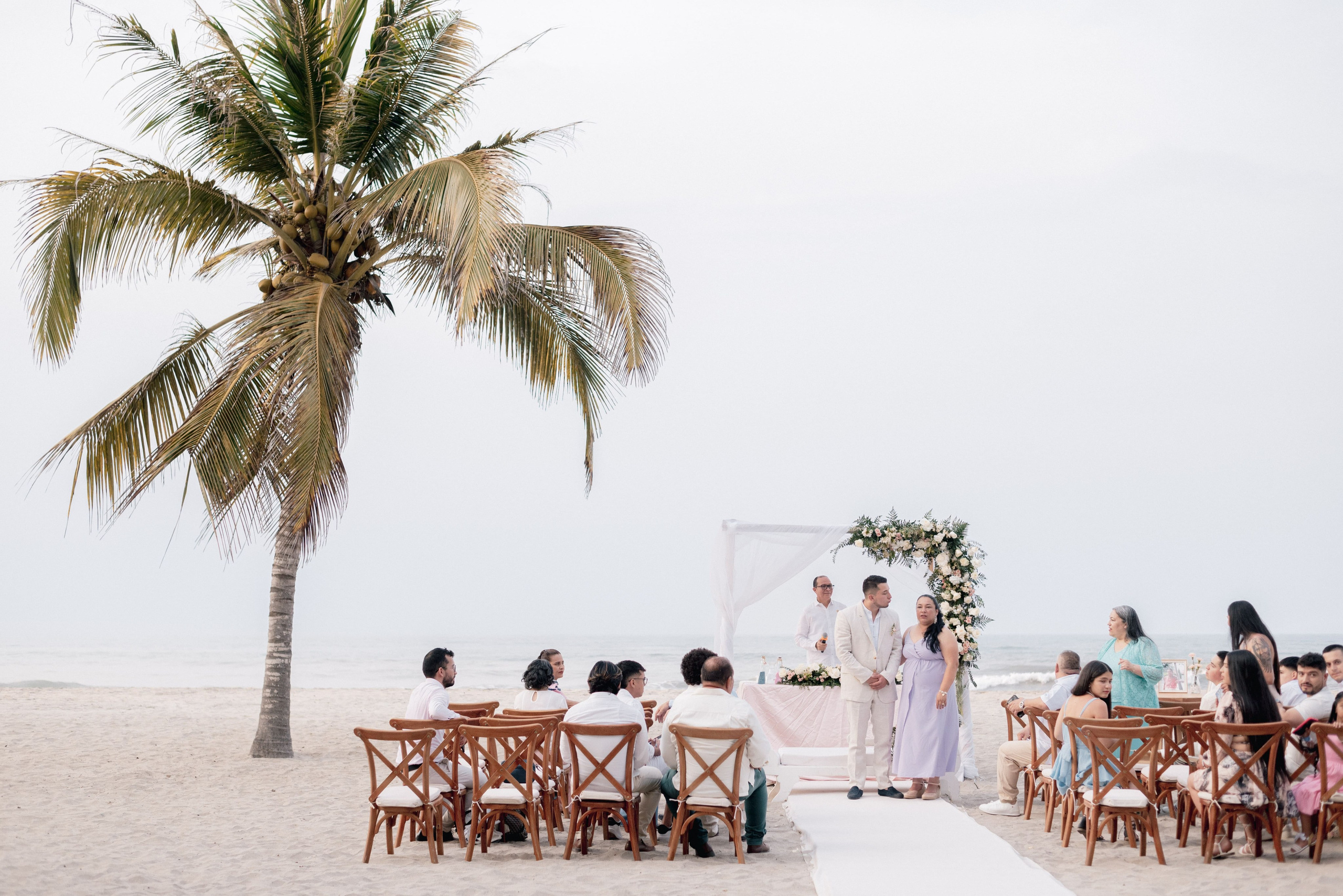 Pareja besándose en boda de playa tropical, momento romántico de ceremonia matrimonial Mareygua