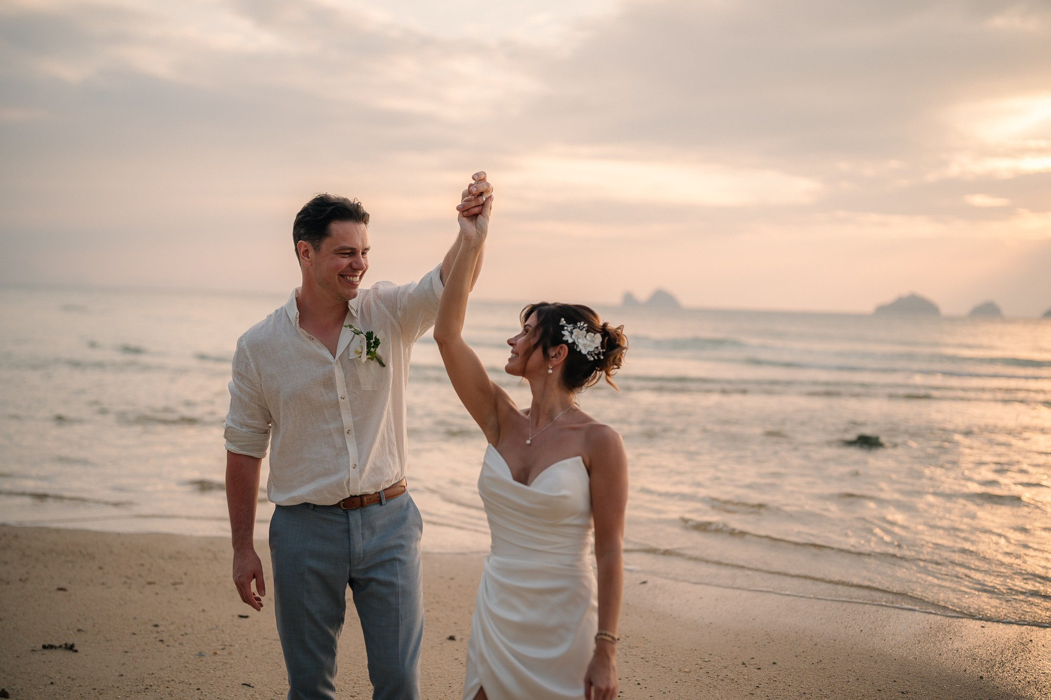 Bride and groom celebrating a beach wedding with their children in Koh Samui, Thailand, surrounded by tropical scenery and ocean views
