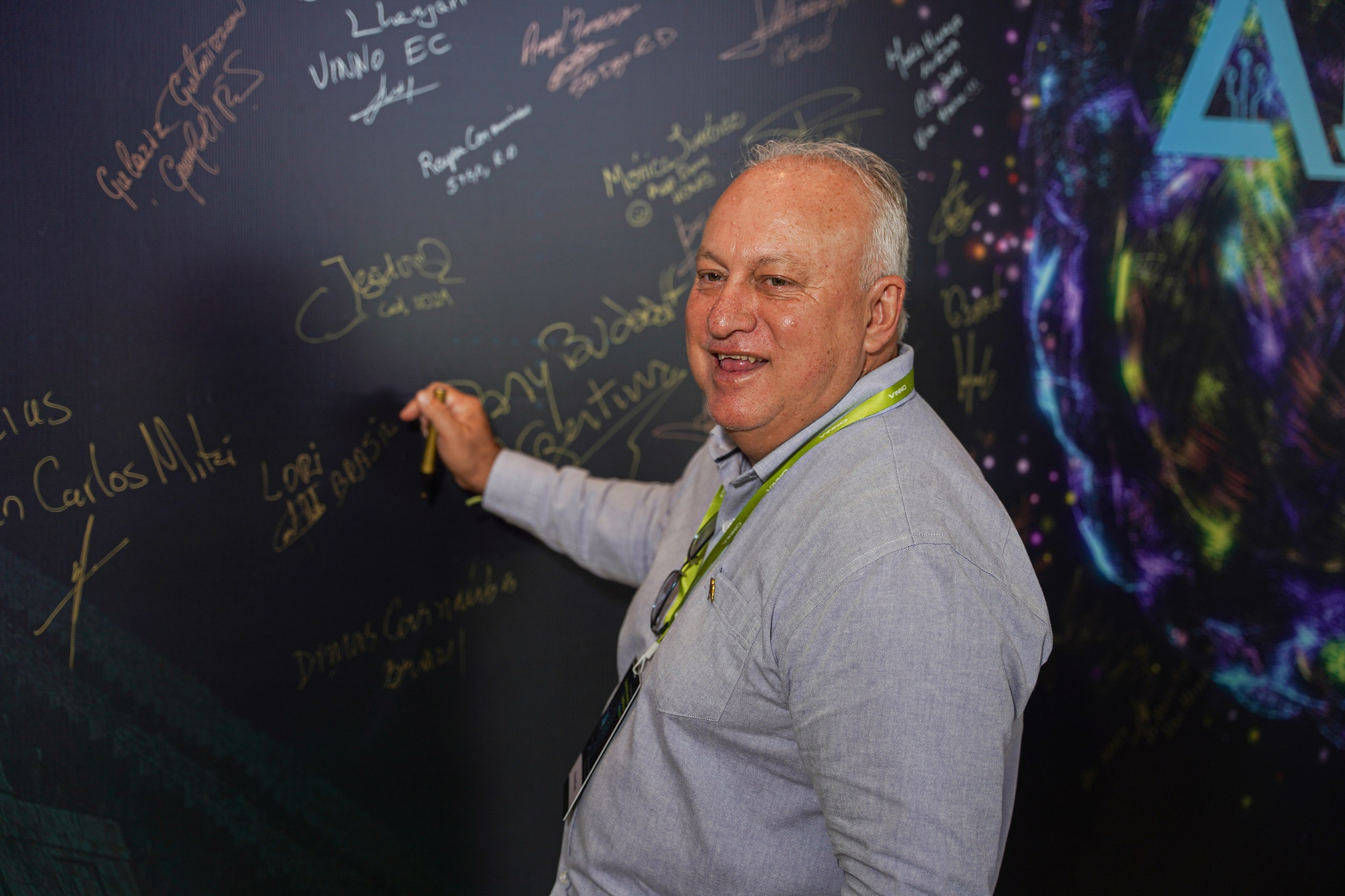 Speaker signing corporate backdrop after completing presentation.