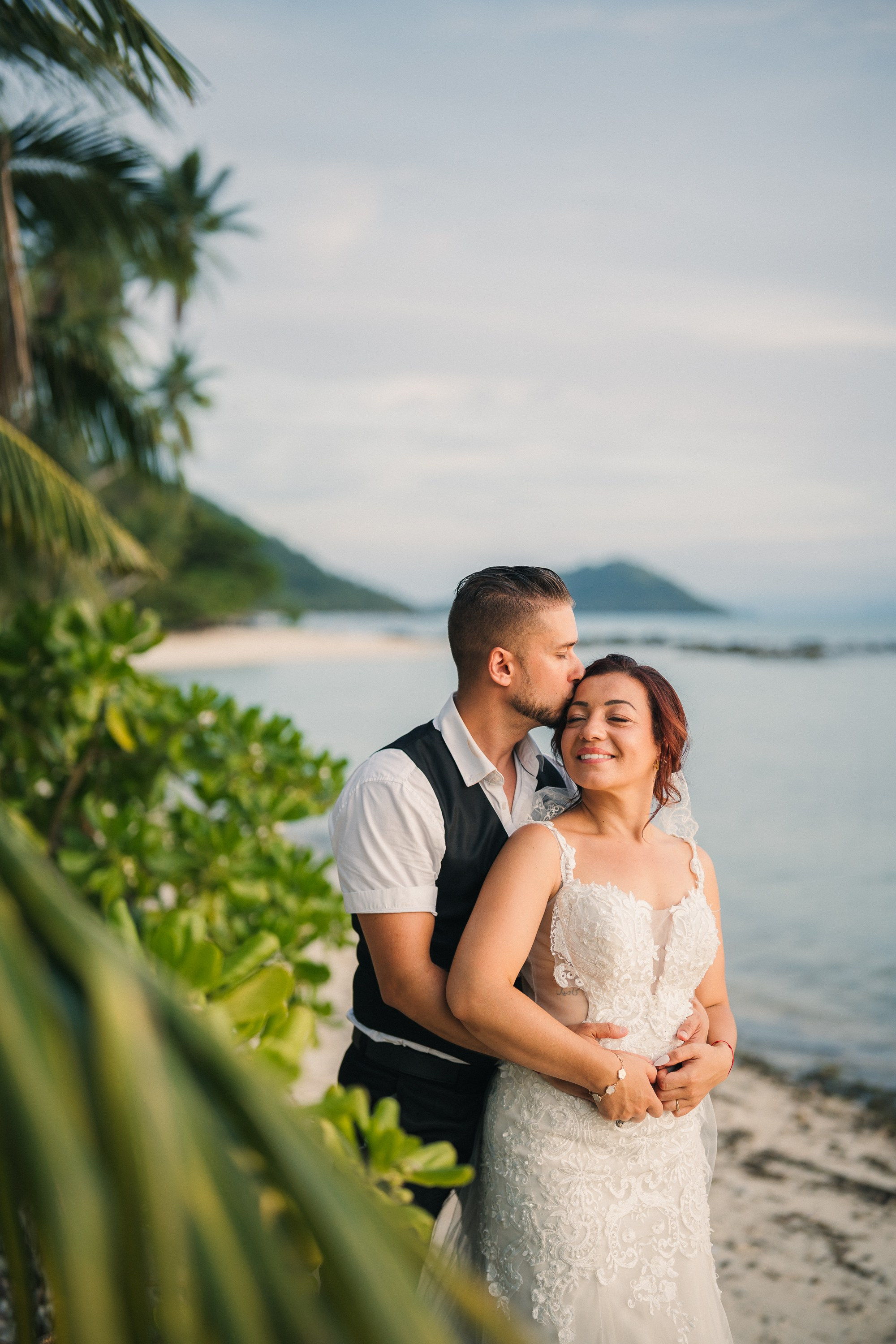 Intimate family wedding on the beach in Koh Samui, Thailand with the couple and their children enjoying the ceremony together
