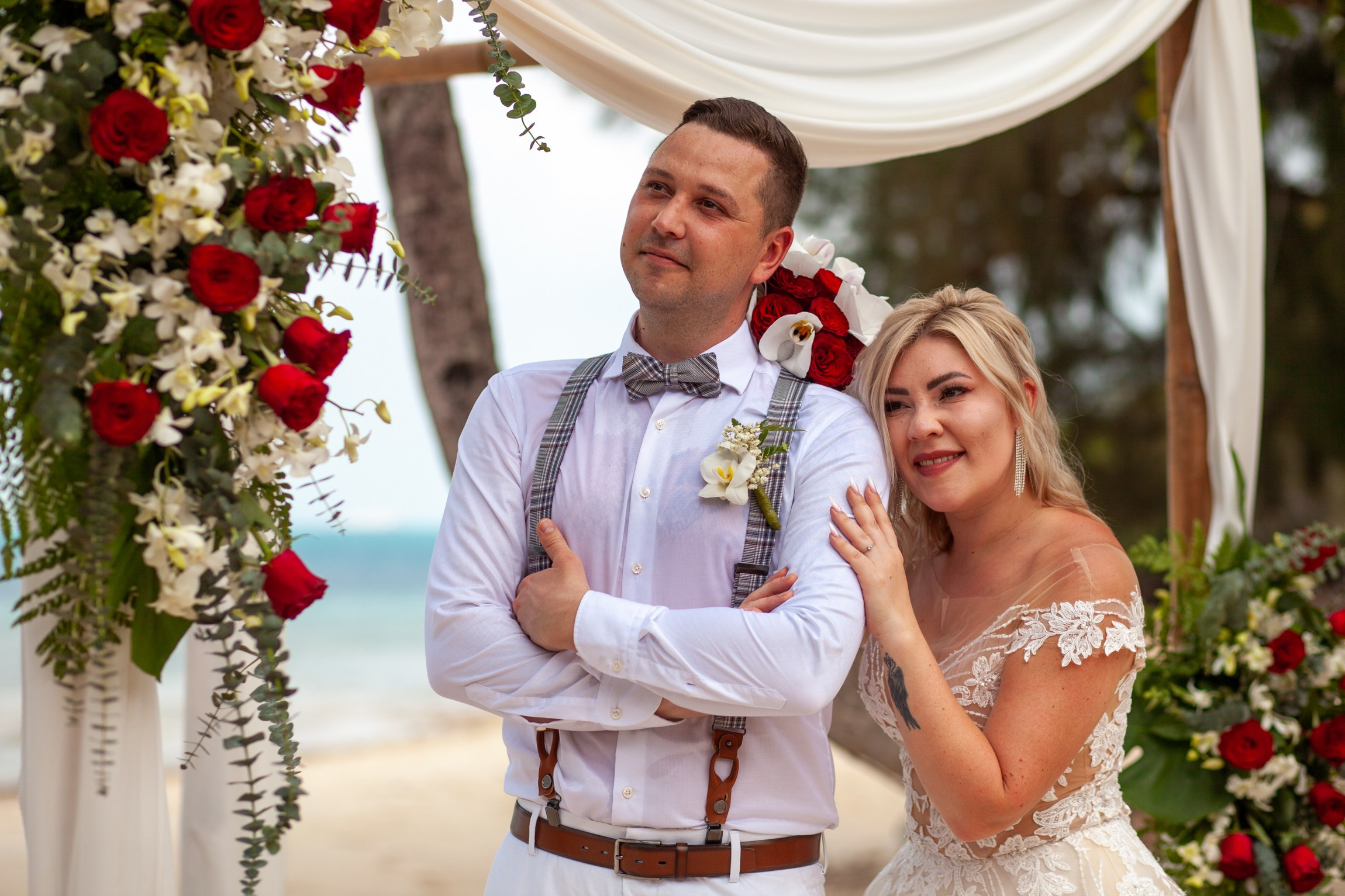 Elegant beach wedding setup on Koh Samui, Thailand with bride, groom, flowers and stunning sea backdrop