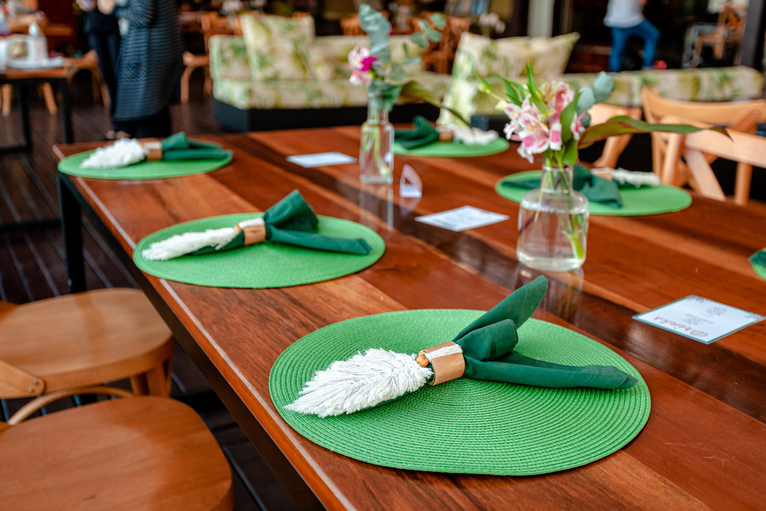 Fotógrafo festa de formatura em Balneário Camboriú; detalhes da mesa posta e decoração elegante com jogos americanos verdes e arranjos florais no Bali Bistro Beach.