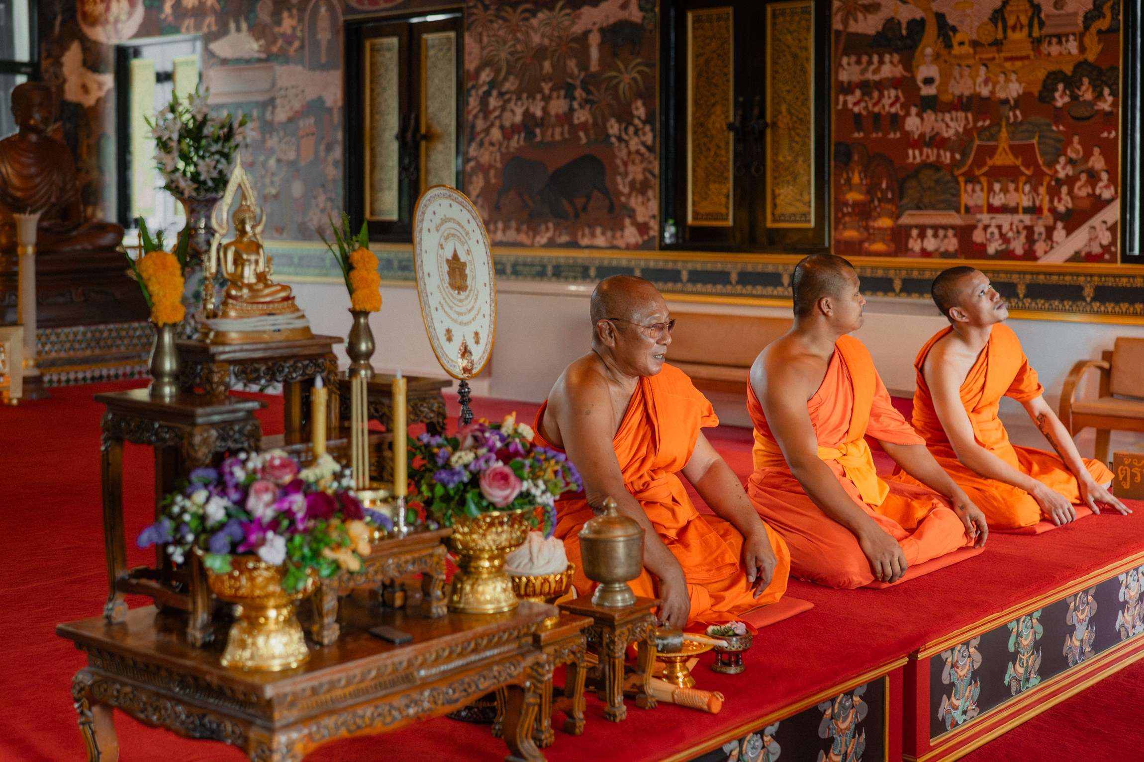 Bride and groom participating in a sacred Buddhist wedding blessing in Thailand