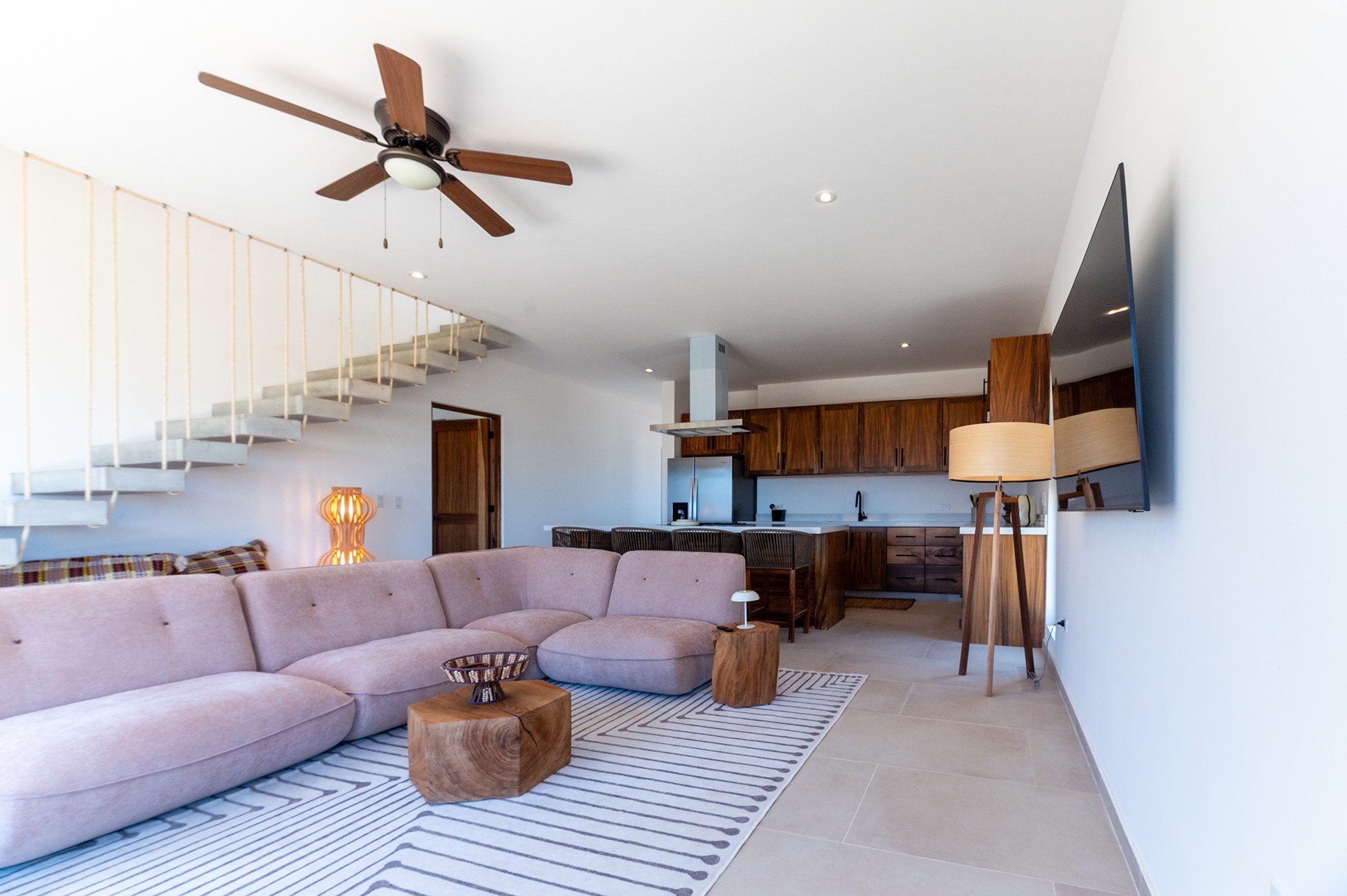Open concept home in Baja California Sur – living room, dining bar, kitchen and staircase to second floor, architectural photography