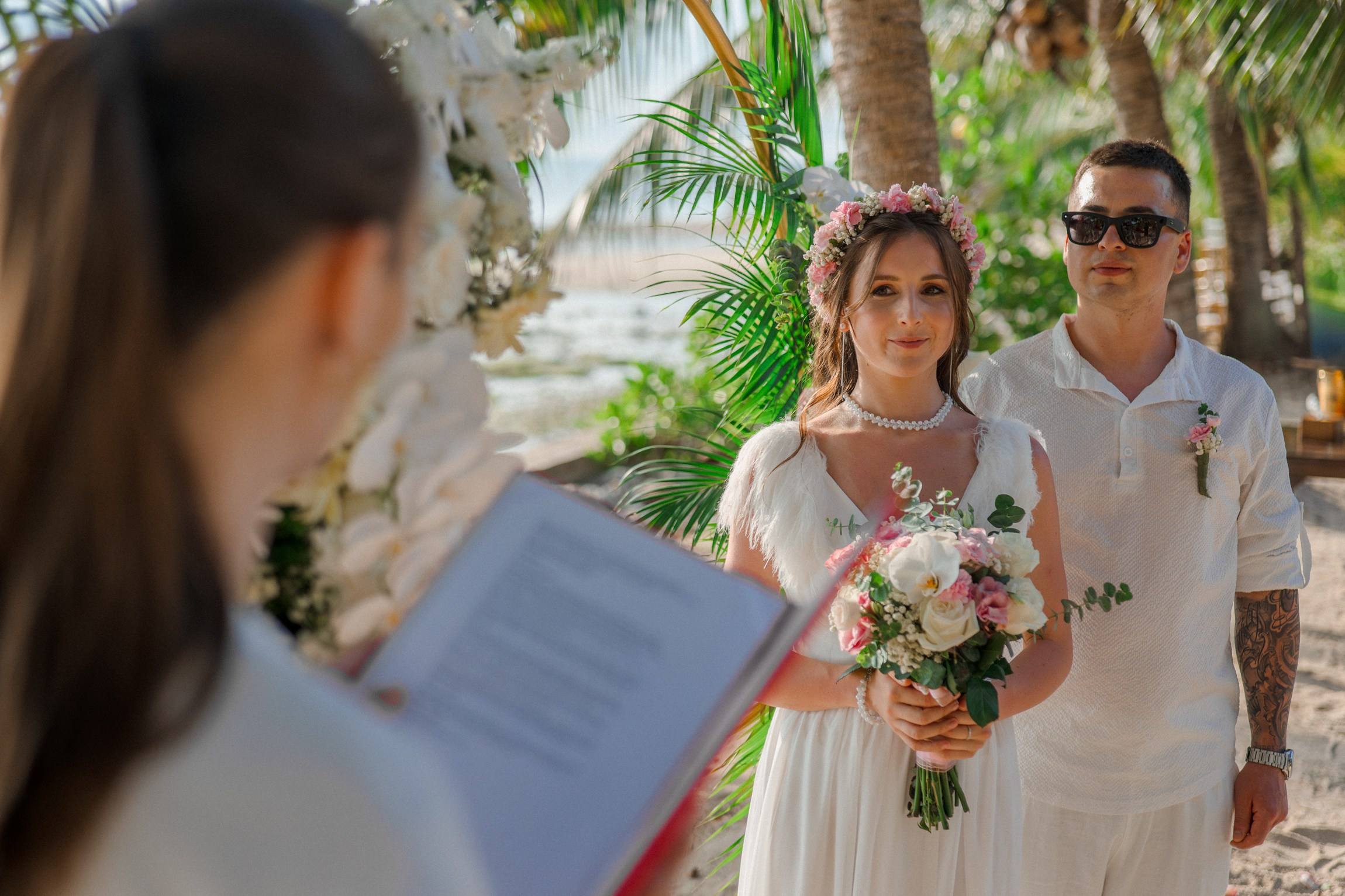 Bride and groom exchanging vows on a private sunset beach