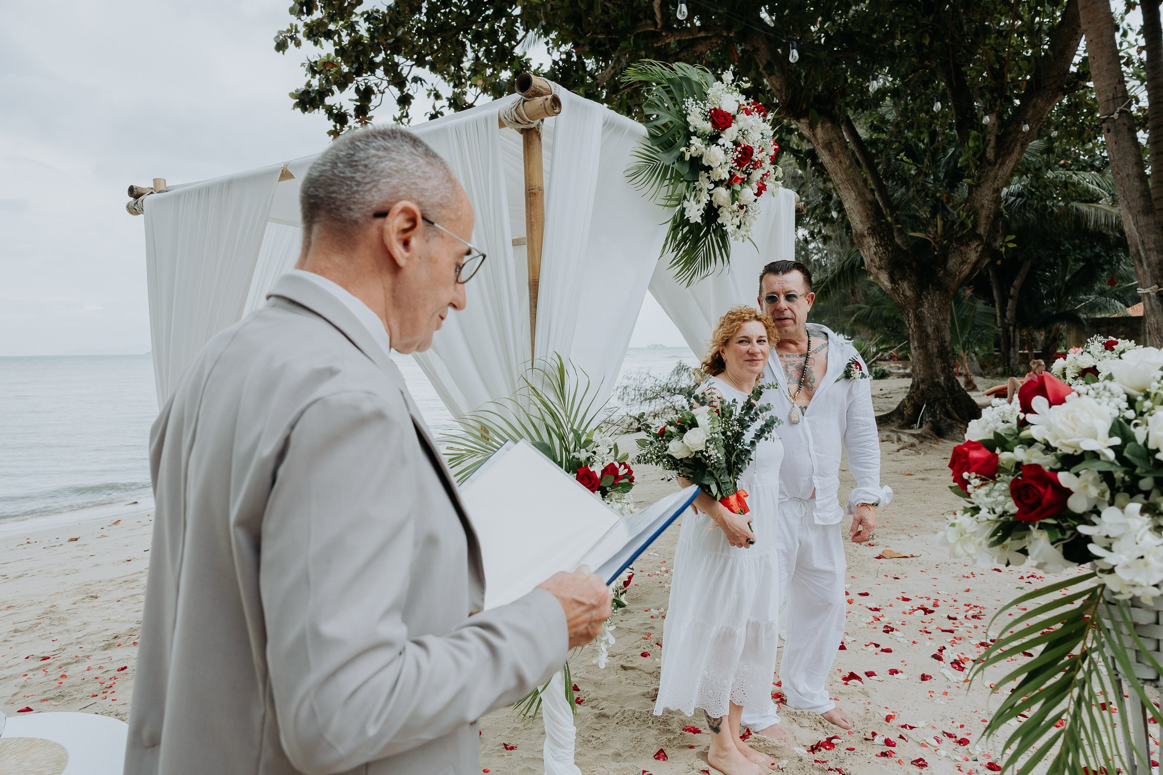 Bride and groom participating in a sacred Buddhist wedding blessing in Thailand