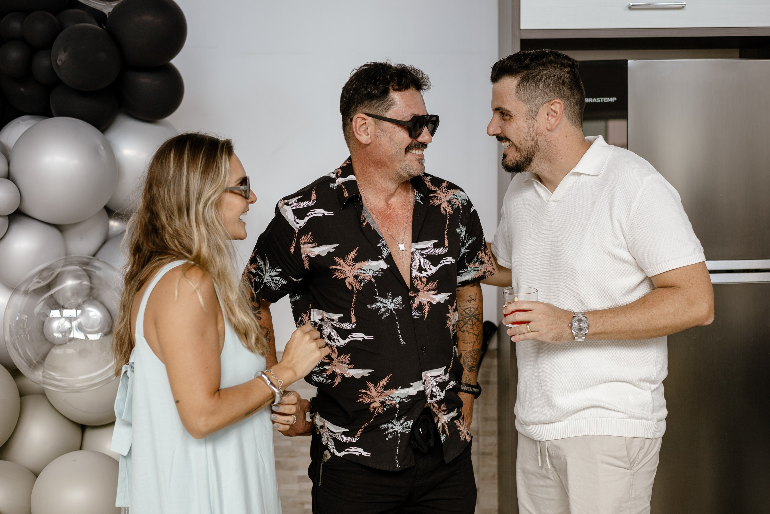 Fotografia de cobertura de festa e evento em Itajaí mostrando os anfitriões conversando animadamente com os convidados durante a comemoração.