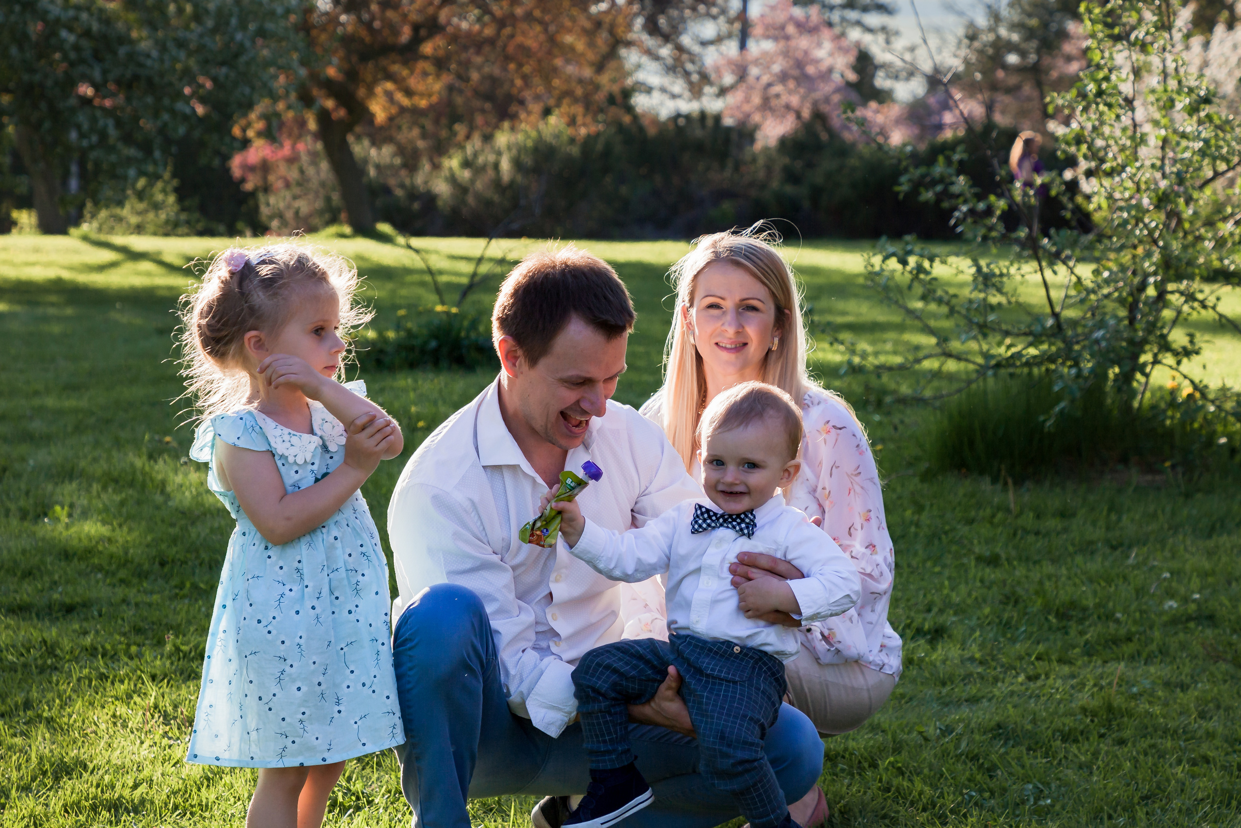 Spring family photo session surrounded by blooming apple trees at Central Experimental Farm in Ottawa.