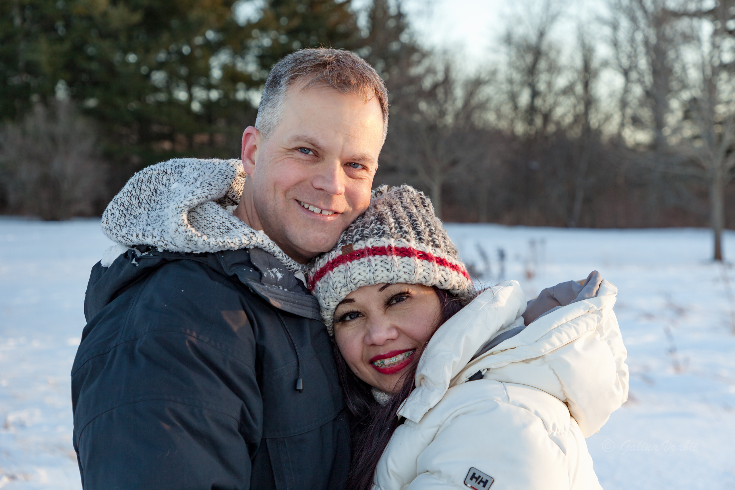 Candid winter session portrait of a couple walking in a snowy landscape. Winter couple's portrait at golden-hour sunset, winter lifestyle photography, Kingston.