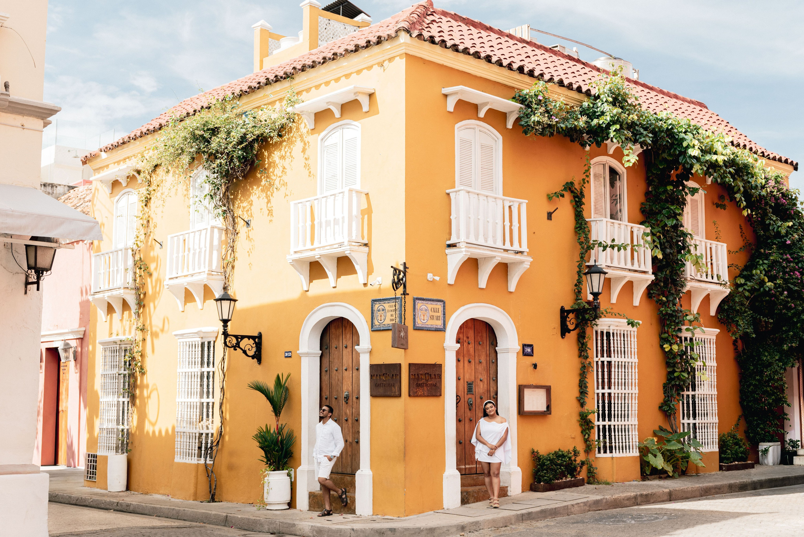 Pareja bajo balcones floridos del Centro Histórico – Preboda en Cartagena, fotografía para bodas y celebraciones especiales.