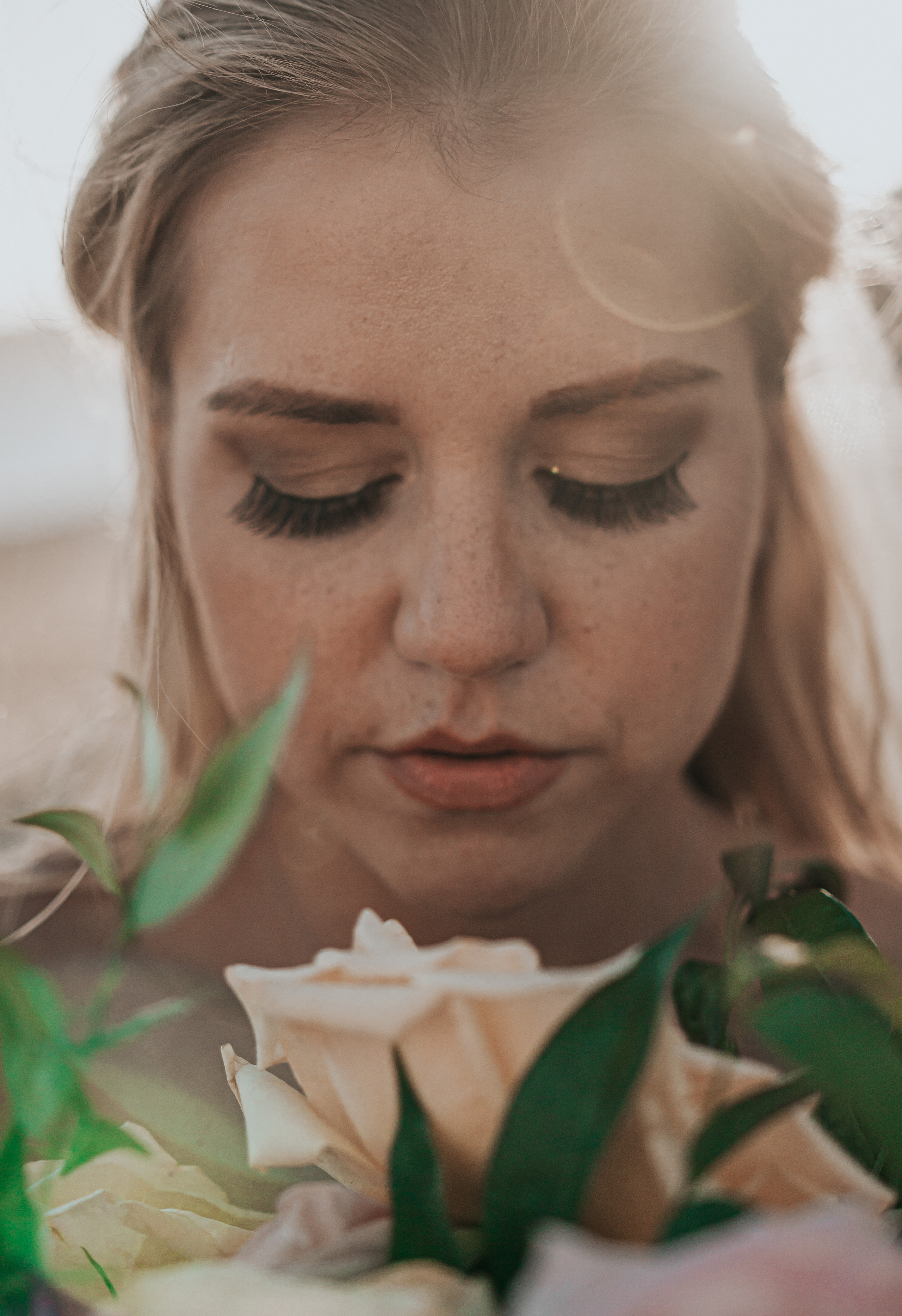Close-up of bride with bouquet and natural makeup during sunset in Cabo