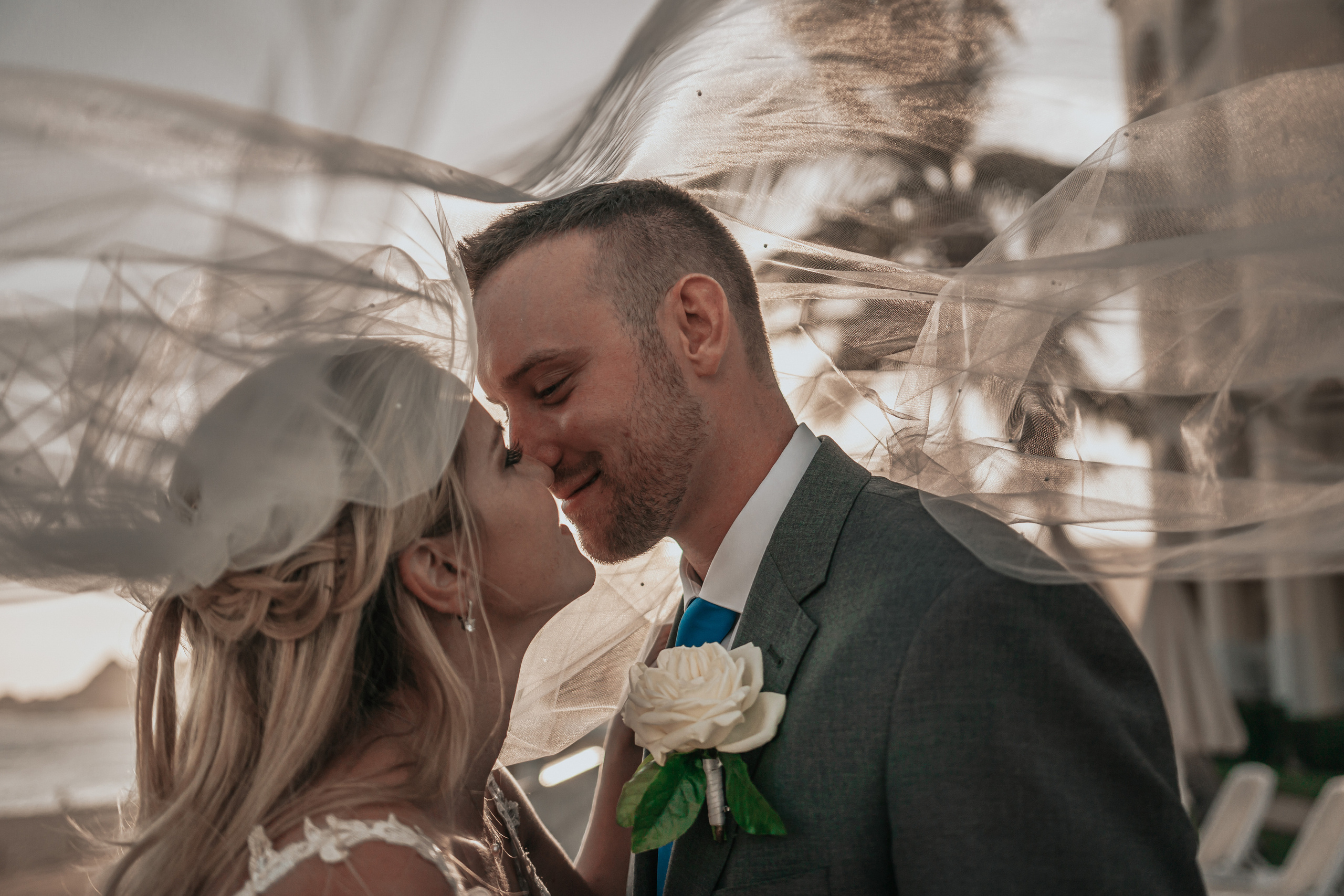 Bride and groom sharing intimate moment with ocean breeze in Los Cabos