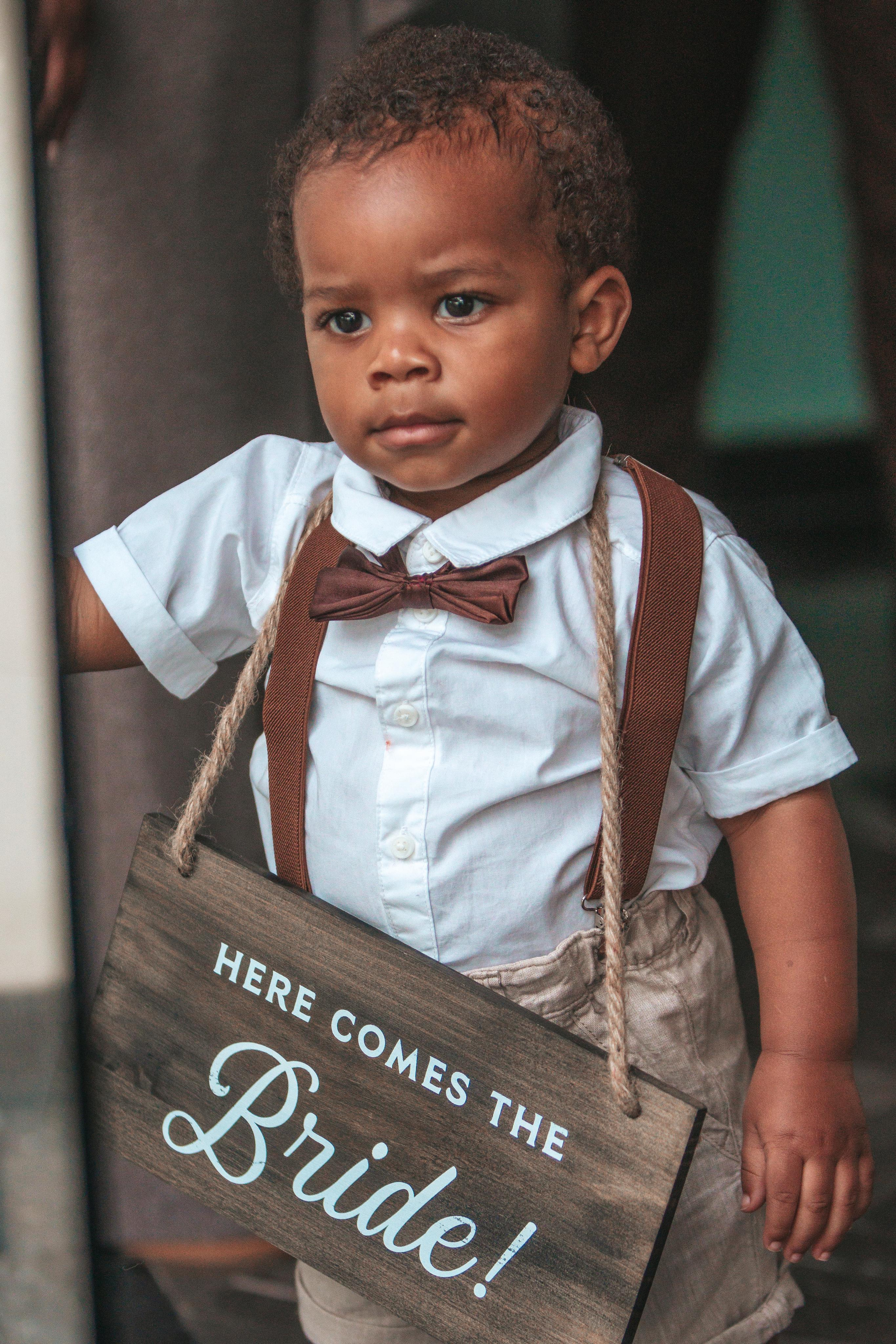 Cute ring bearer holding “Here comes the bride” sign – wedding photographer Cancun