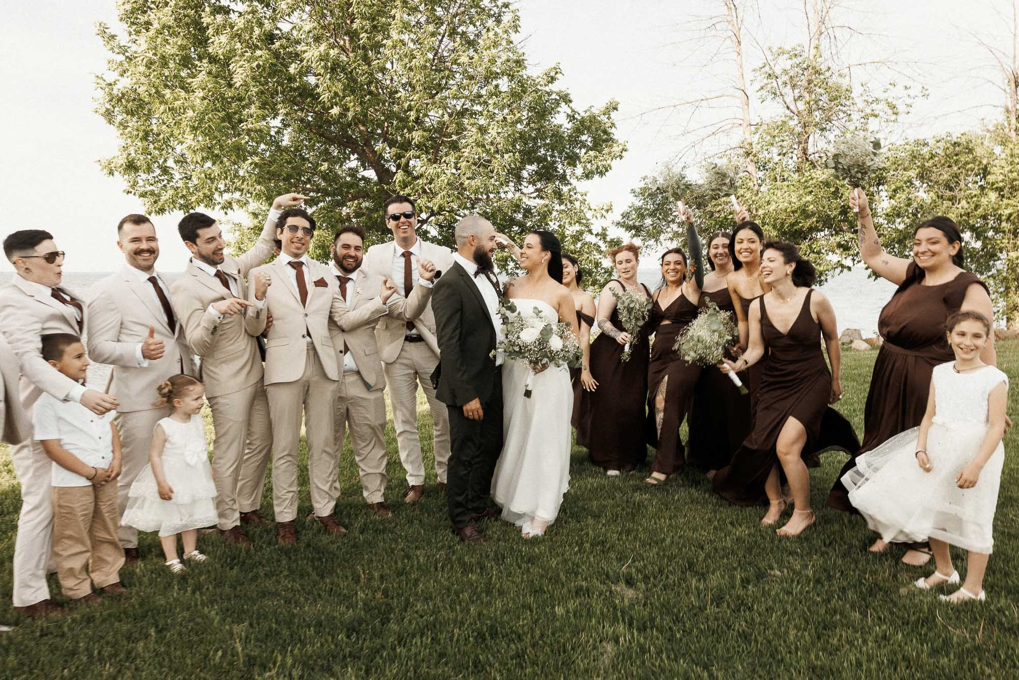 The wedding party celebrates together by the waterfront near Montreal.