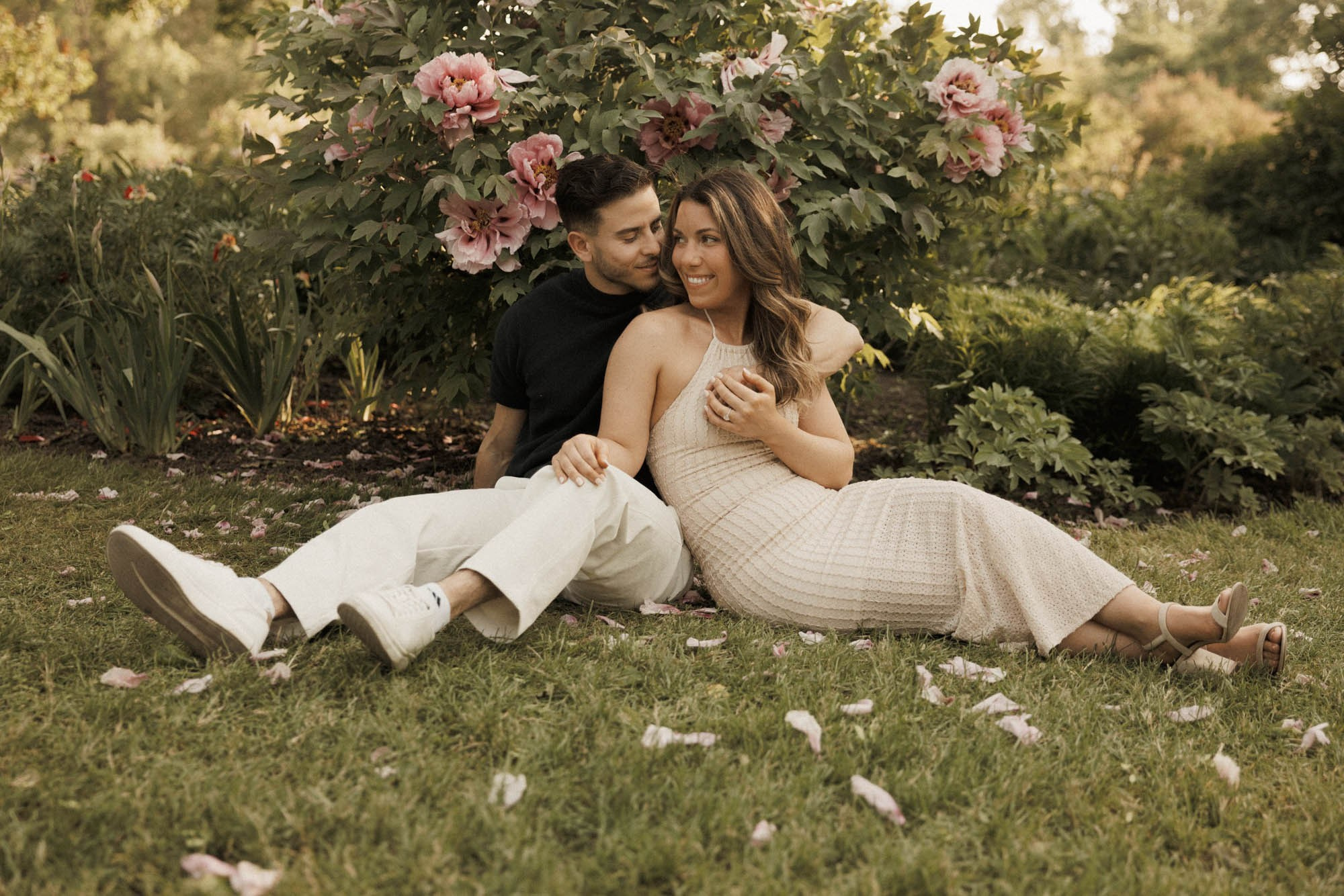 Couple sitting close together in a flower garden