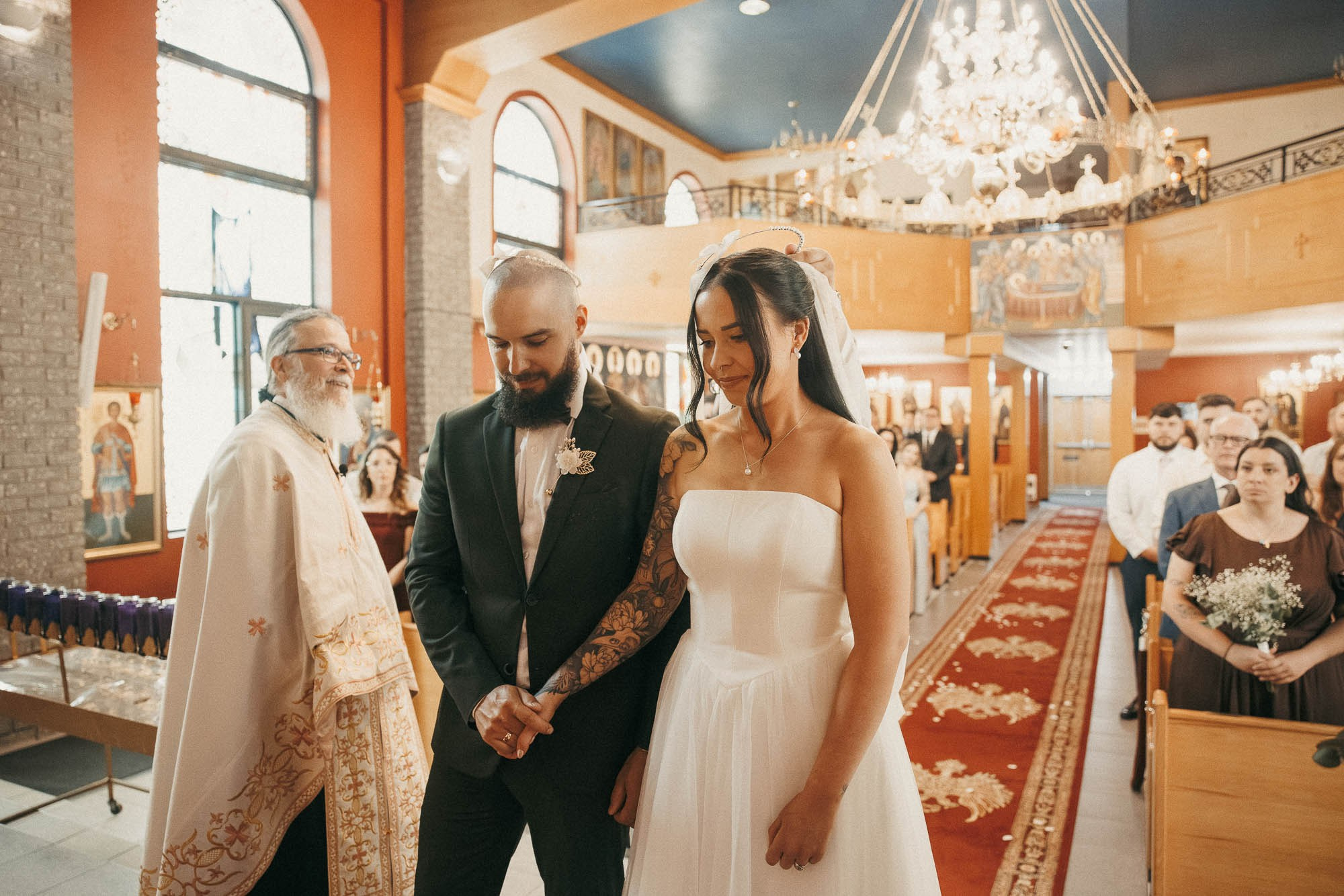 Kendyl and Mikey hold hands beside the priest during their ceremony.