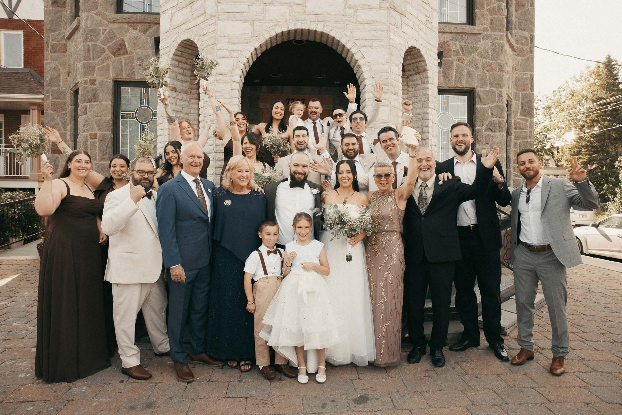 Family and wedding party gather for a group portrait outside the church.