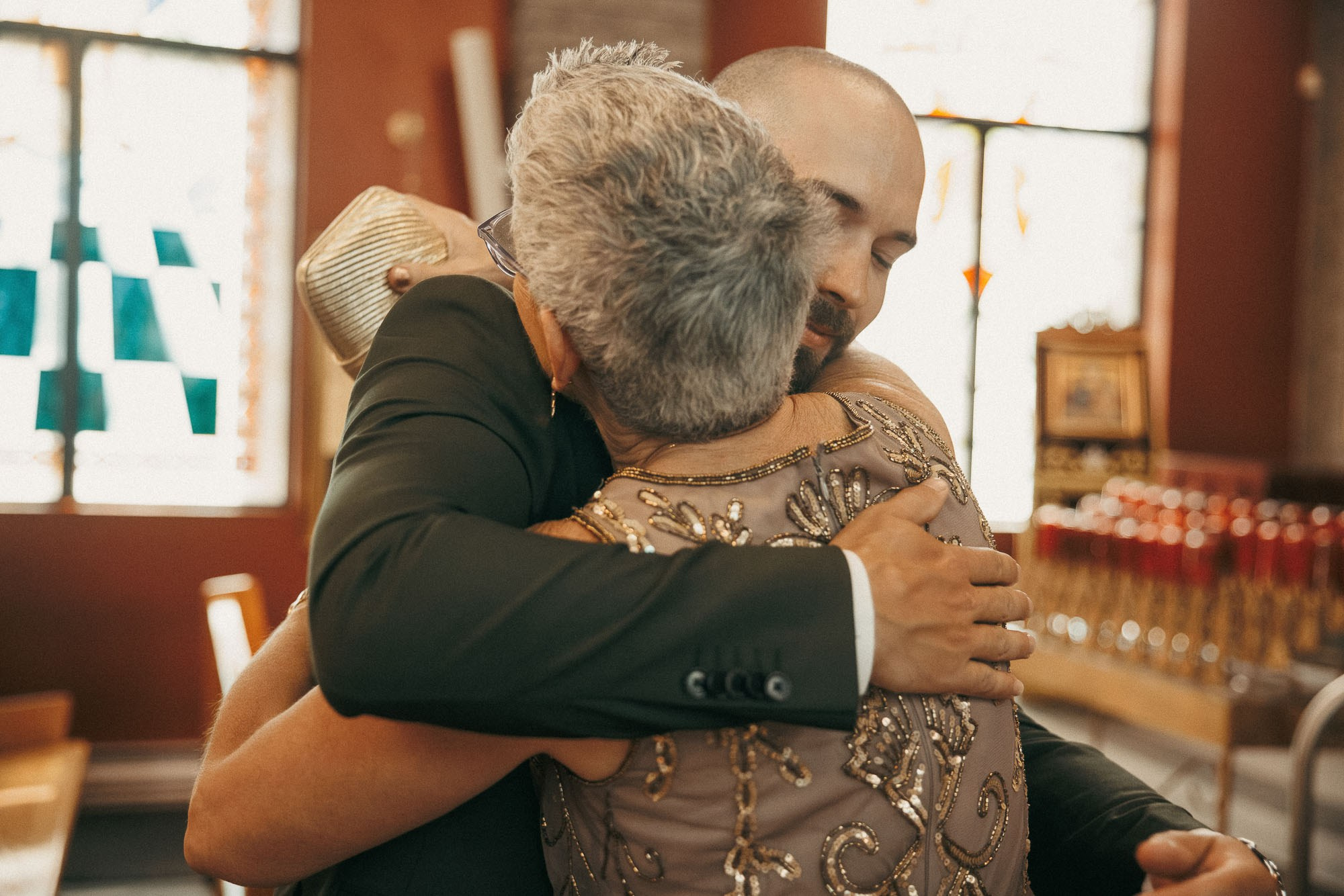 The groom embraces his mother during the church processional.