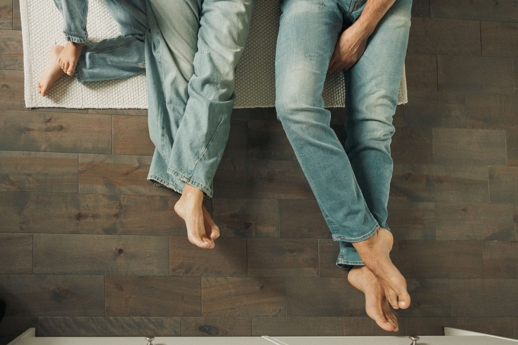 Close-up of an expecting couple sitting barefoot together at home