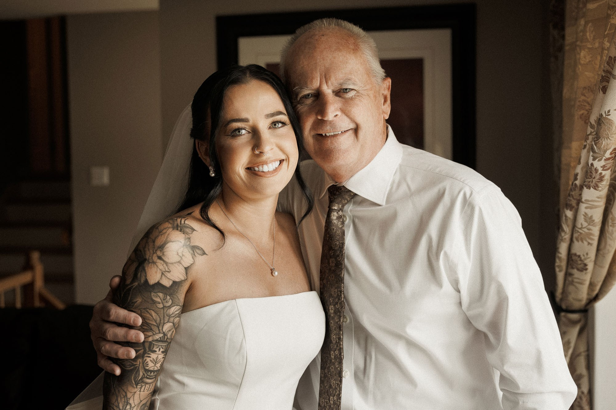 The bride smiles beside her father before the church ceremony.